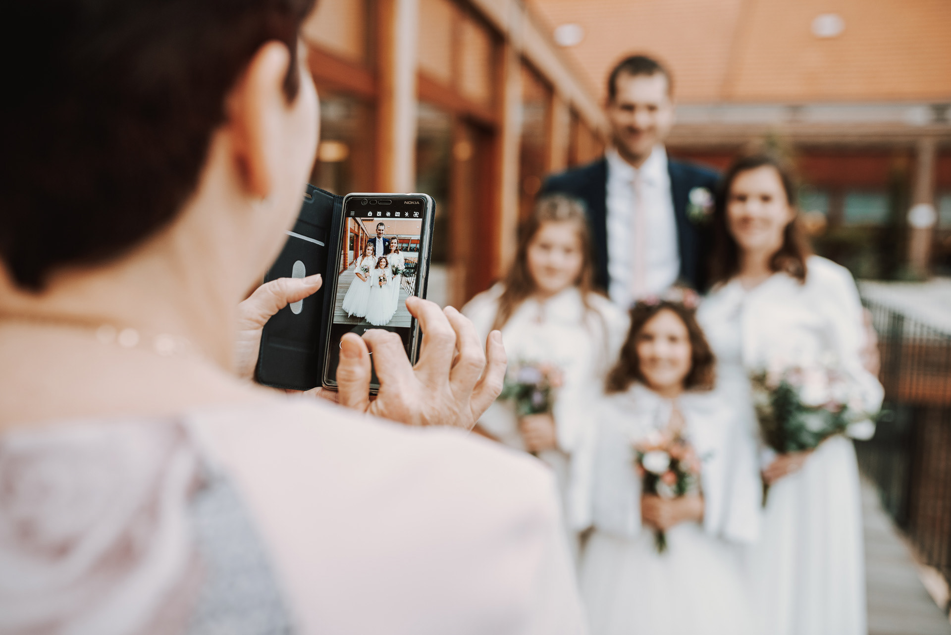 detail mobilní telefon a na něm fotka šťastné rodiny