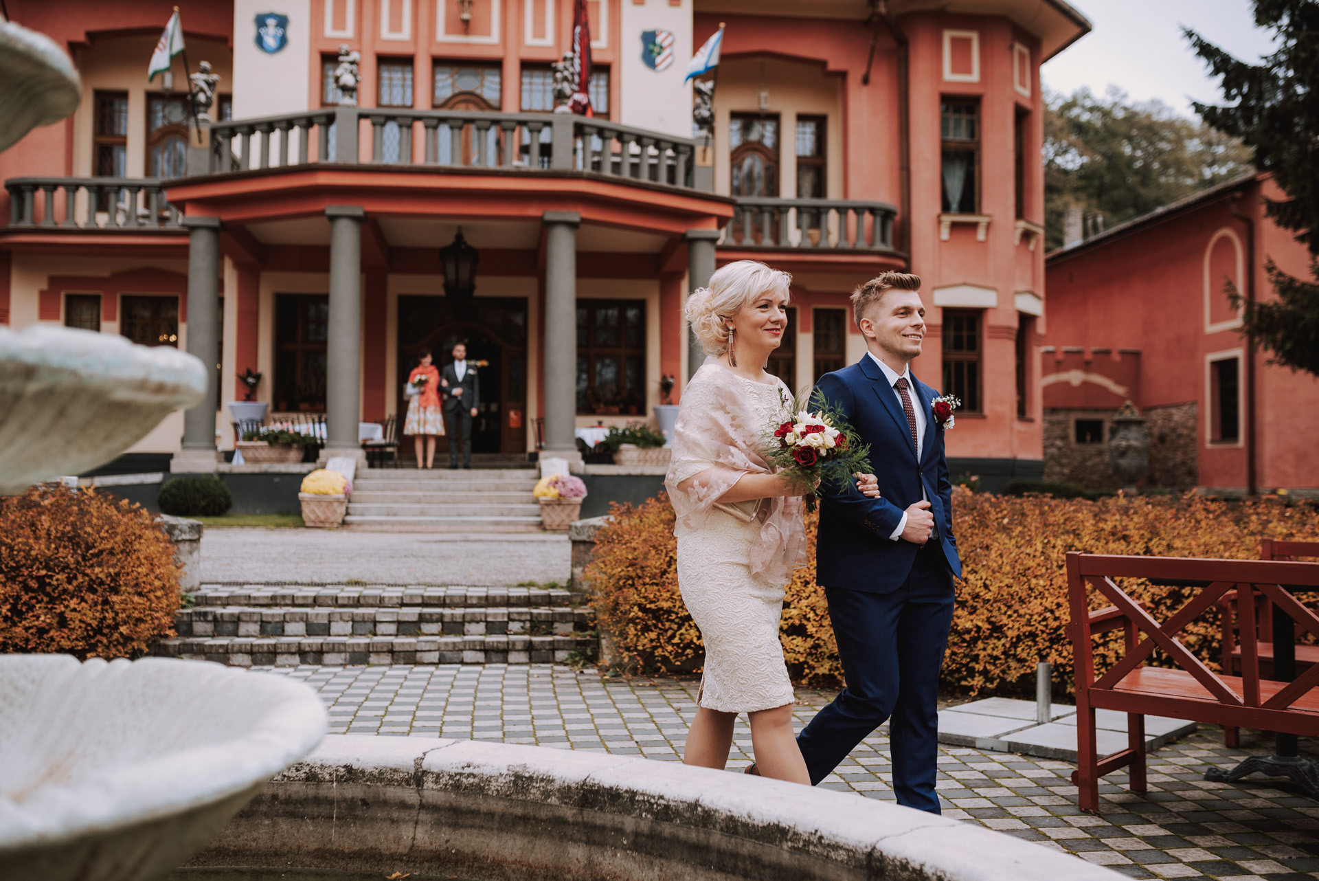 maminka s ženichem kráčí k obřadu před letohrádkem