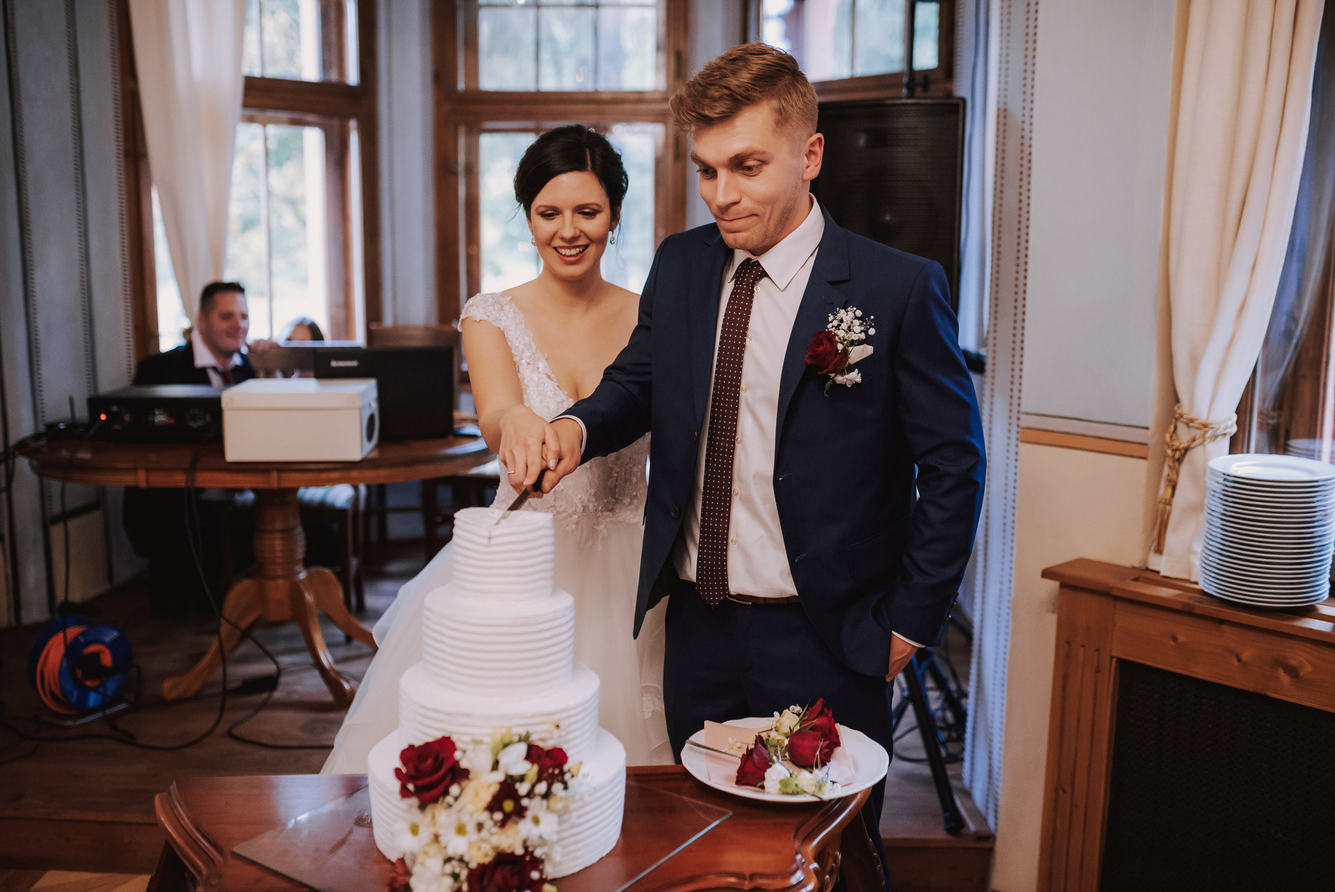 ženich s nevěstou krájí svatební dort