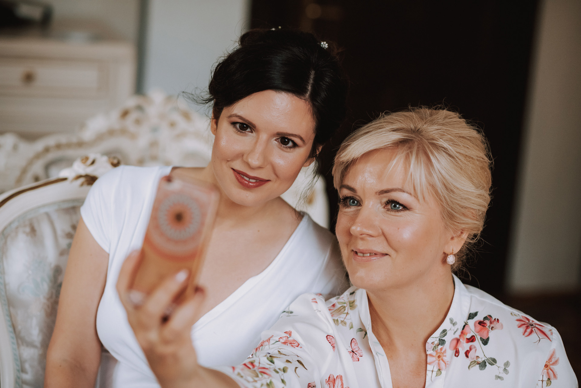 nevěsta s maminkou ženicha si dělají společnou fotku na mobil