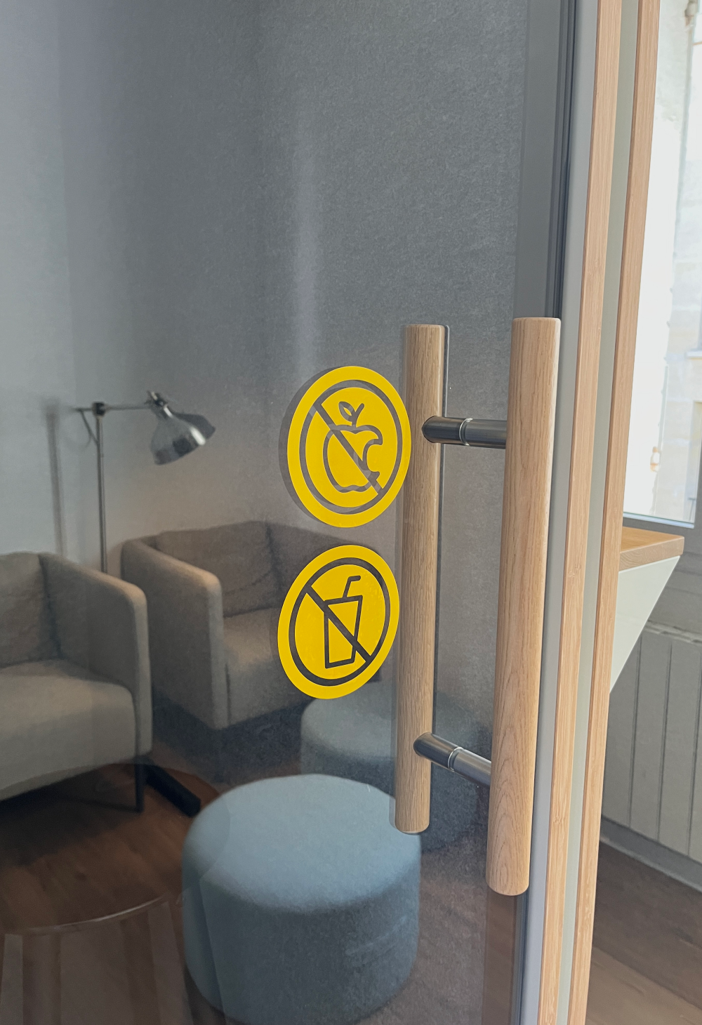 Deux stickers semi-transparents interdisant le fait de manger et de boire dans la cabine insonorisante