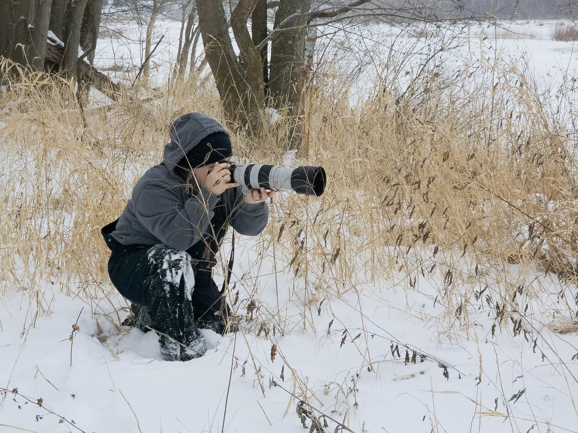 northwest ohio photographer crouched down in snow holding camera