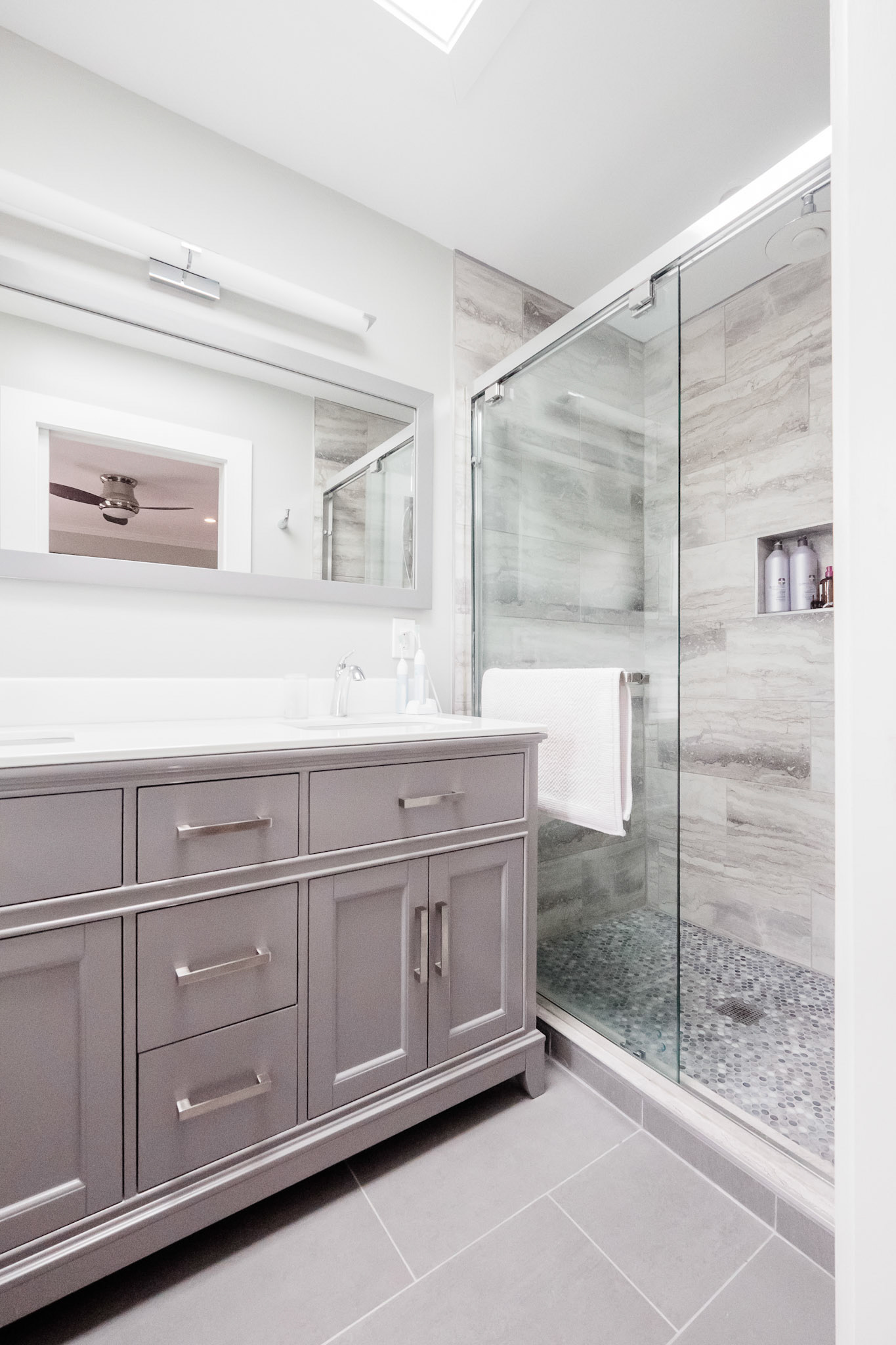 The ensuite bathroom has a large shower and double sink vanity.