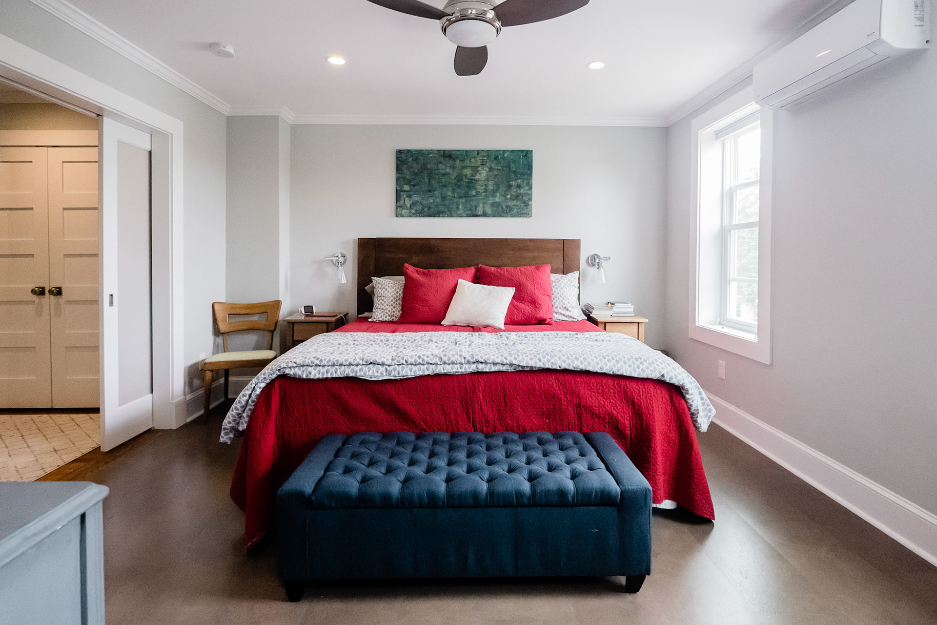 The new main bedroom on the second floor of the addition includes pocket doors to the dressing room for privacy.