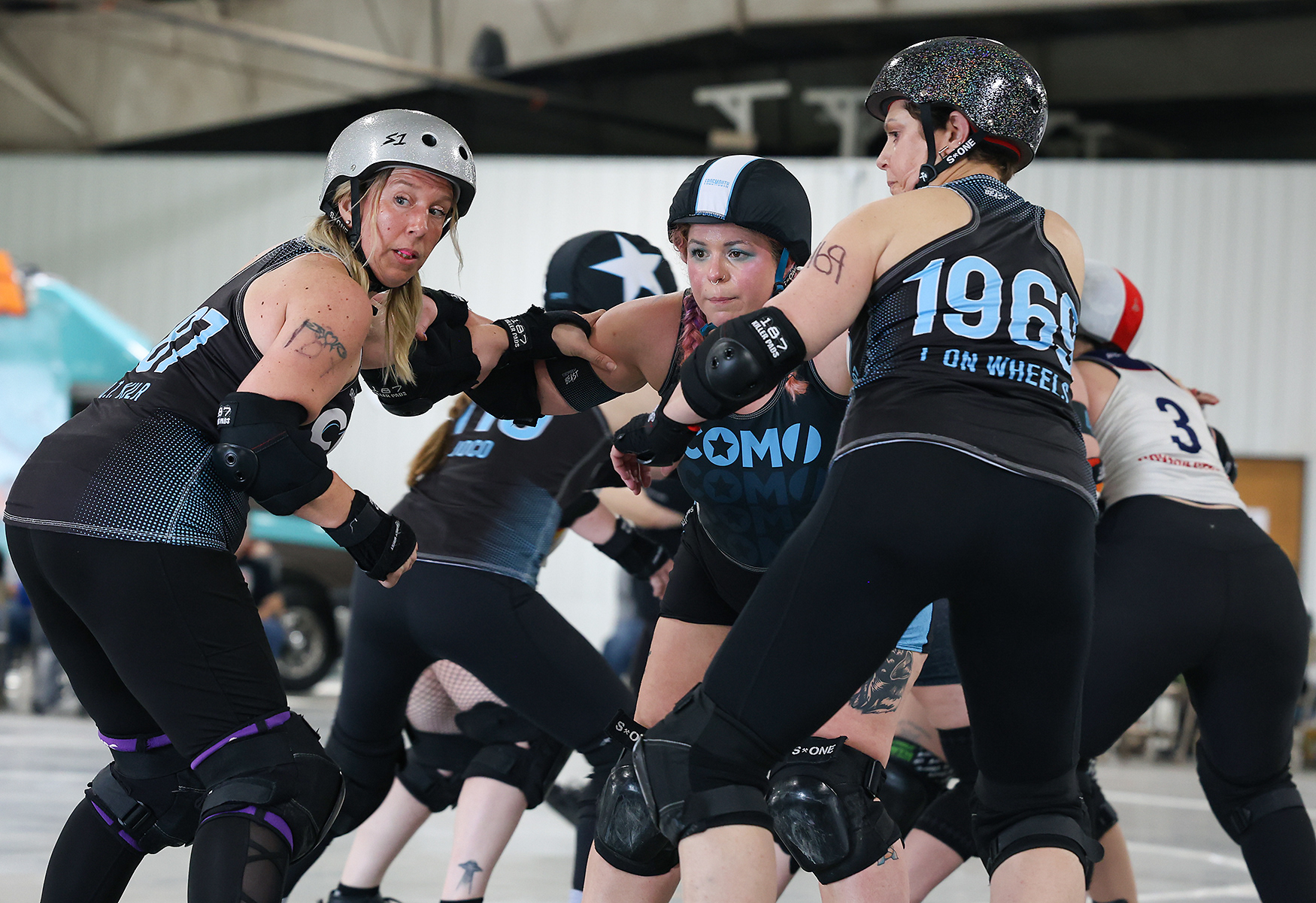 Kelsey Mescher, known as Mesch’er Up (17) on the track, leads the defense with Rebecca Harrison, known as Q. T. Kilr, left, (187) and Laura Pruitt, known as L on Wheels, right, (1969) against Roughneck Tulsa Elite on April 11 at the Bob Lemone Building in Hallsville. Mescher’s striped helmet designates her as a pivot, the team’s defensive anchor.