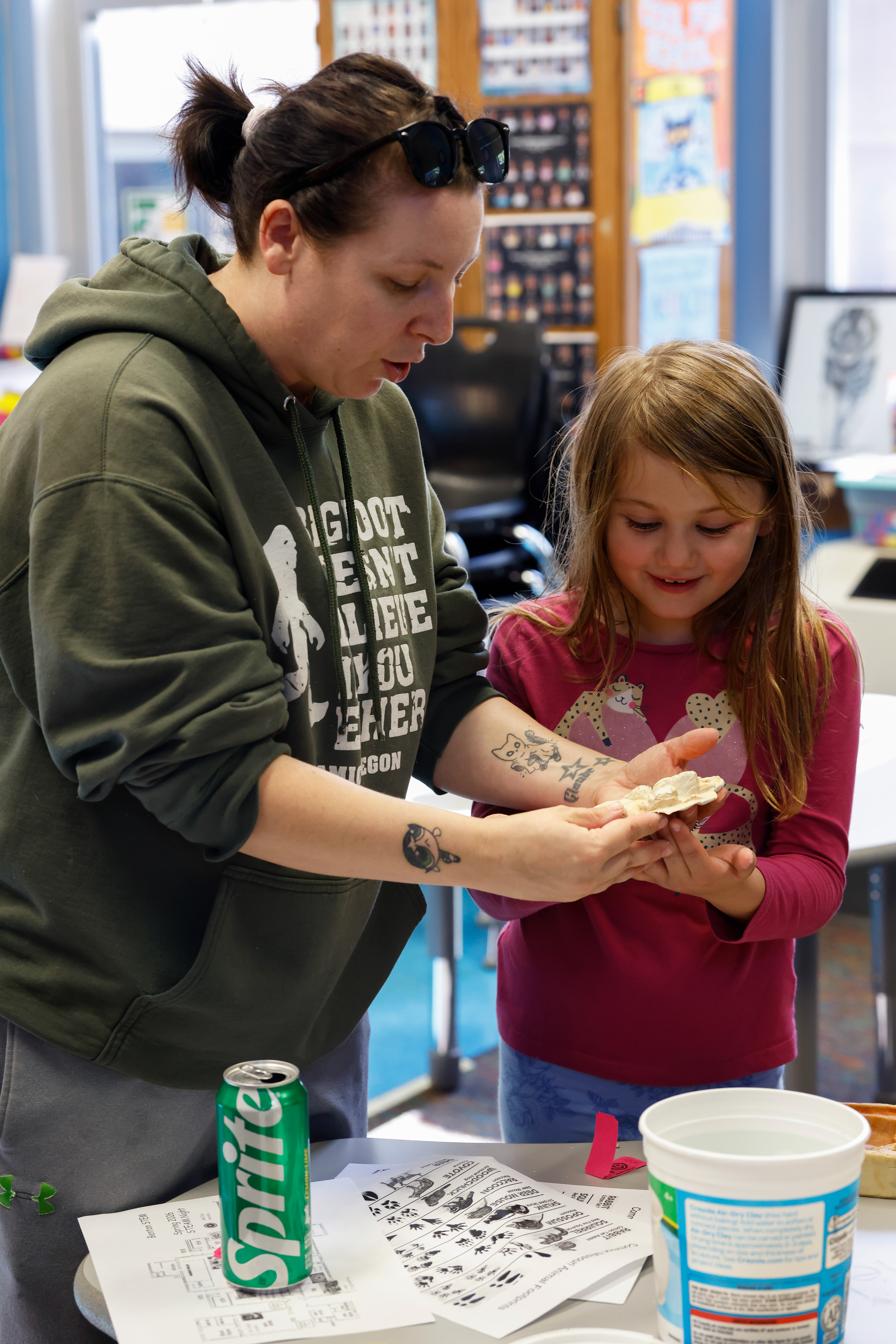 From right, Benton first grader Sophia Newman, 7, makes a black bear footprint mold with her aunt, Tayla Sorge, at a STEAM night event on May 7 at Benton STEM Elementary School in Columbia. Sophia’s mother Hilary Newman said they go to all the STEAM night events.