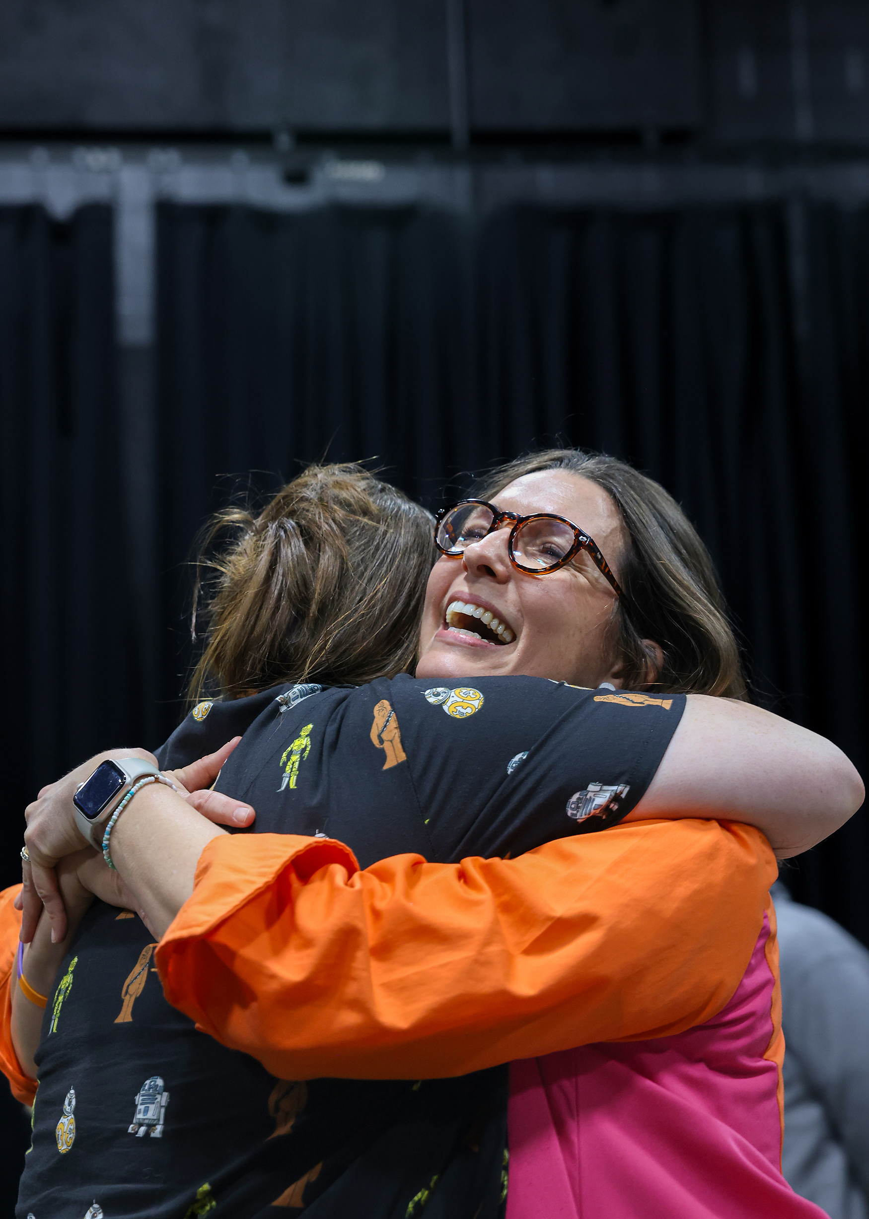 Principal Samantha Adams hugs another third grade teacher Lindsey Woodcock at the art gallery on March 20 at Locust Street Expressive Arts Elementary School in Columbia. “I love seeing how proud the kids are of their work,” Woodcock said.