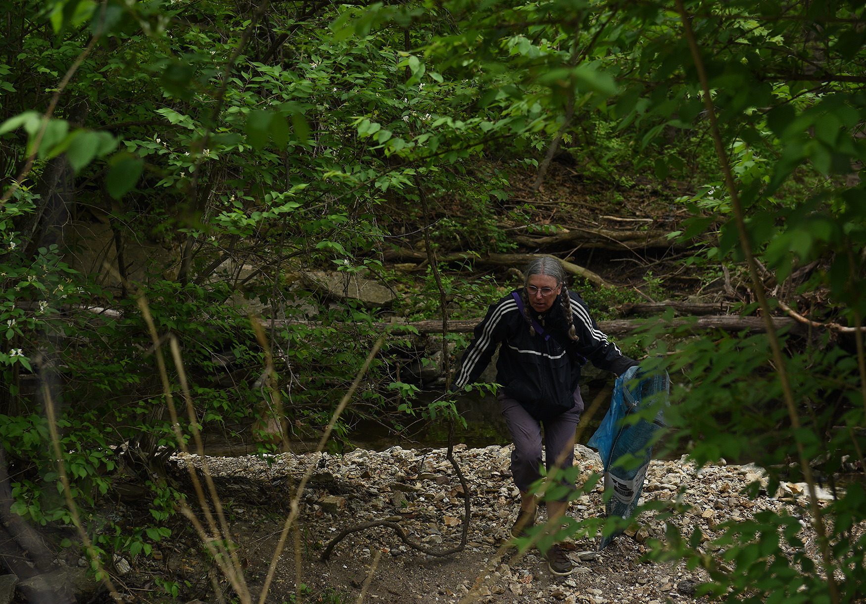 Elke Boyd carries waste away from Flat Branch Creek on Wednesday at the MKT Nature and Fitness Trail in Columbia. Boyd braved a flare-up of hay fever to spend the morning helping Missouri River Relief’s cleanup efforts.