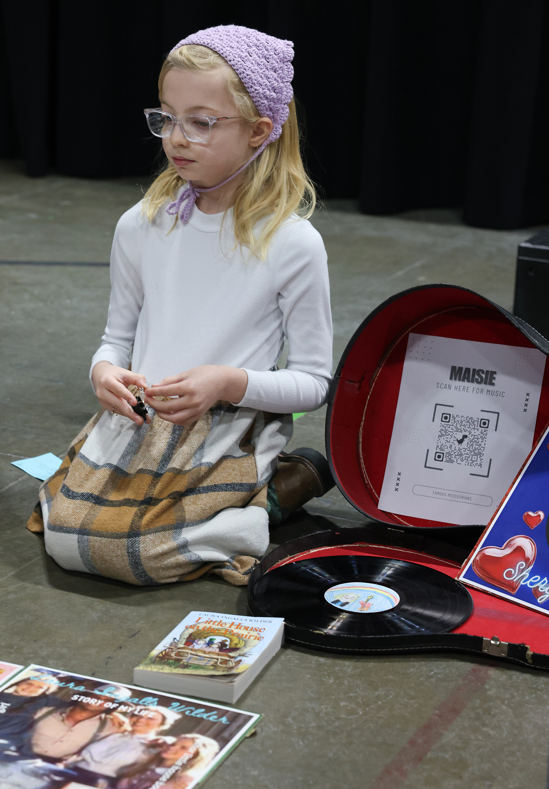 Karis Donnelly, 8, explains her artwork at the art gallery on March 20 at Locust Street Expressive Arts Elementary in Columbia. Karis brought a guitar to the showcase and came dressed as Margaret Thatcher.