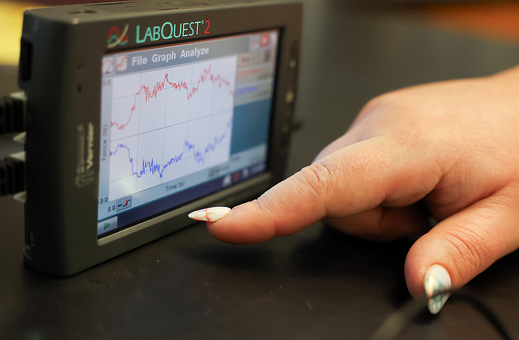 Kelsey Mescher points to a force graph during a physics lab on March 31 at Battle High School in Columbia. Students were instructed to bump small cars together and measure equal force interactions using the force graph.