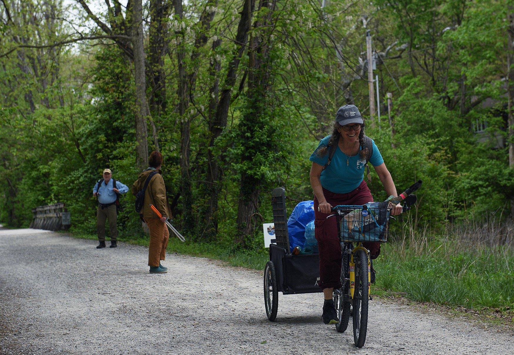 Missouri River Relief crew member Laura Semken pedals away with a load of garbage bags Wednesday at the MKT Nature and Fitness Trail in Columbia. After collecting waste, Semken used her bike to transport the bags to a collection site. The cleanup is one of many Missouri River Relief planned in the coming months.