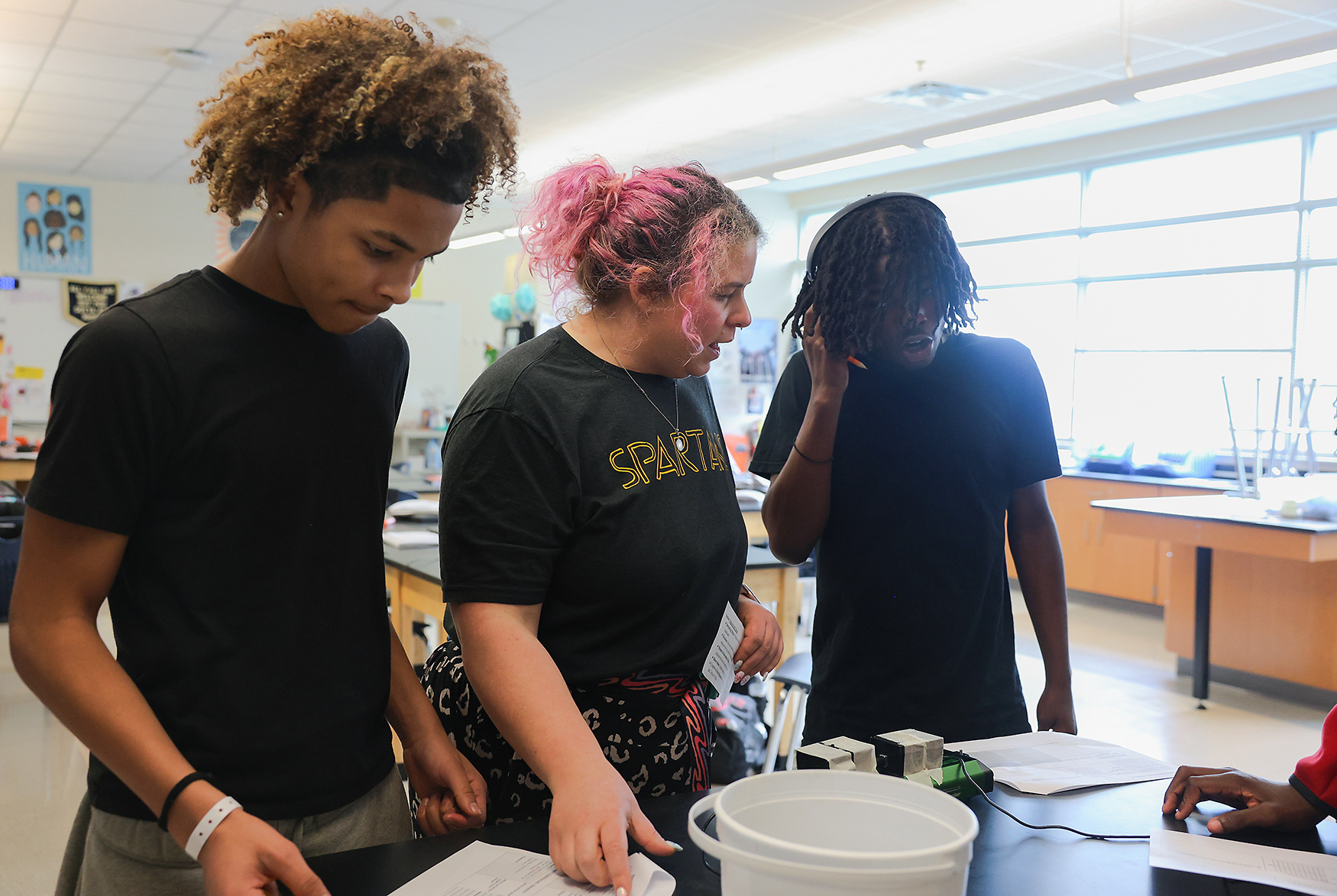 Kelsey Mescher explains a lab experiment to Battle freshmen Cameron Uhuru (left) and Jay’vion Minnis (right) on March 31 at Battle High School in Columbia. Mescher has taught physics at Battle since 2016 and became a full-time teacher in 2017. 