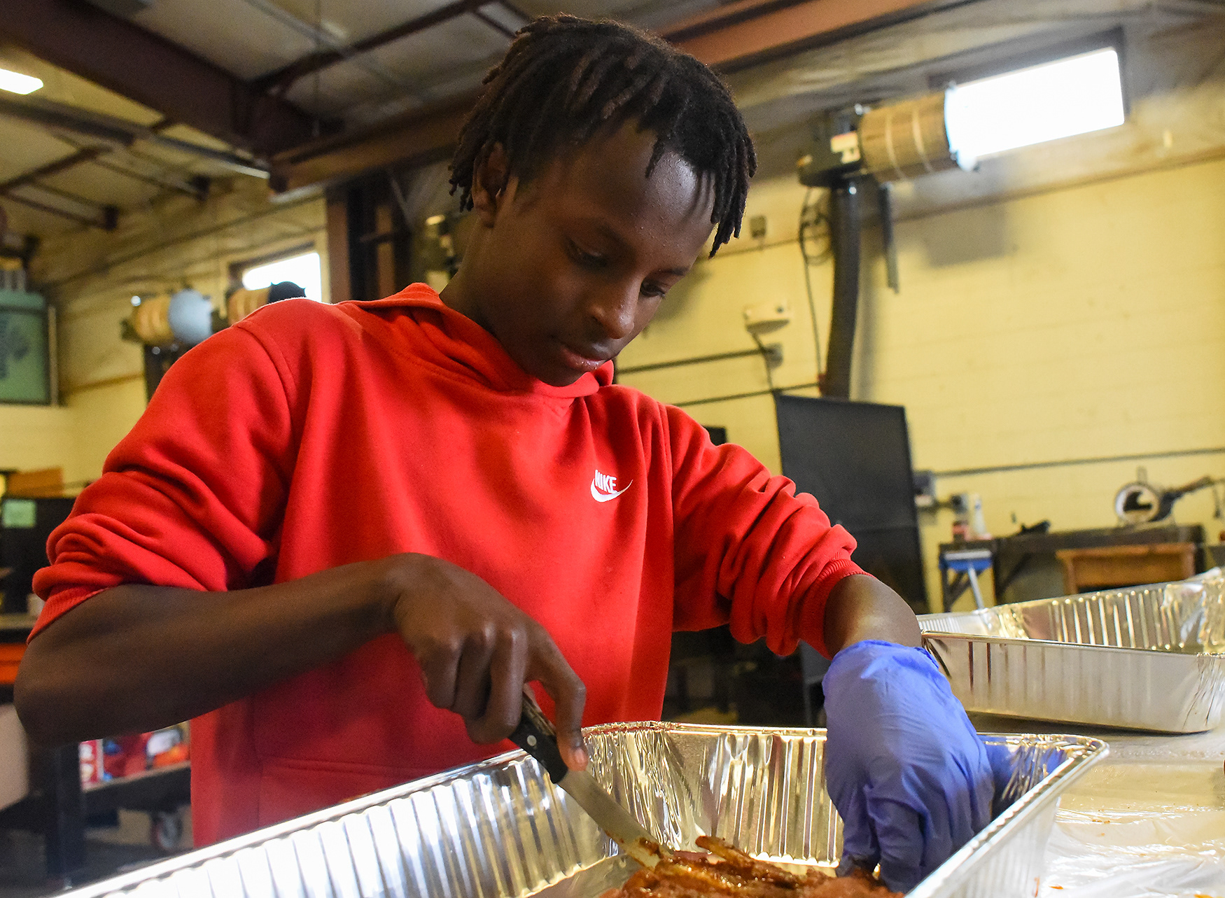 Micah Banks cuts through his finished ribs on March 2 at Hallsville High School. Six students were selected to join a middle school barbecue team.