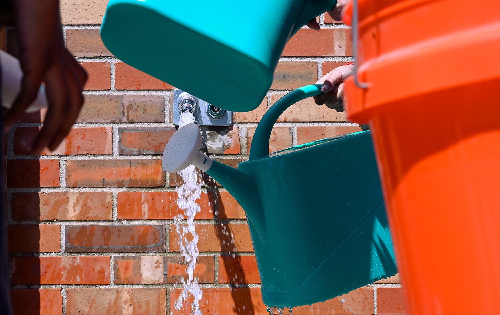 Students fill their watering cans before a Landscaping for Wildlife lesson on April 21 at Jefferson Middle School. This class has planted the majority of the plants on the south side of the building.
