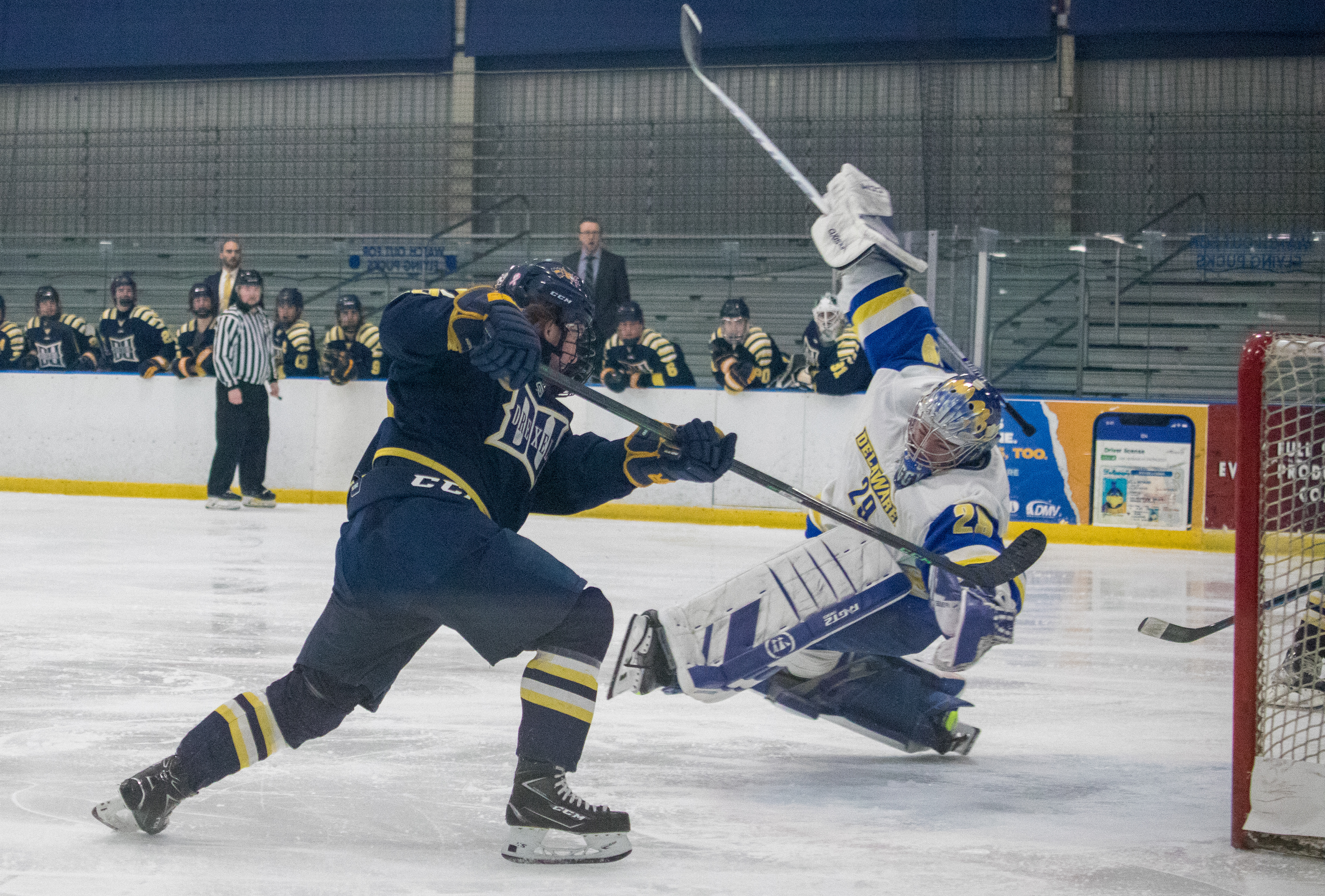 Drexel D1 Forward #29 Ryan Sambuco scores his 1st of the night while the University of Delaware Goalie attempts to make a last resort save on 01/27/2023.
