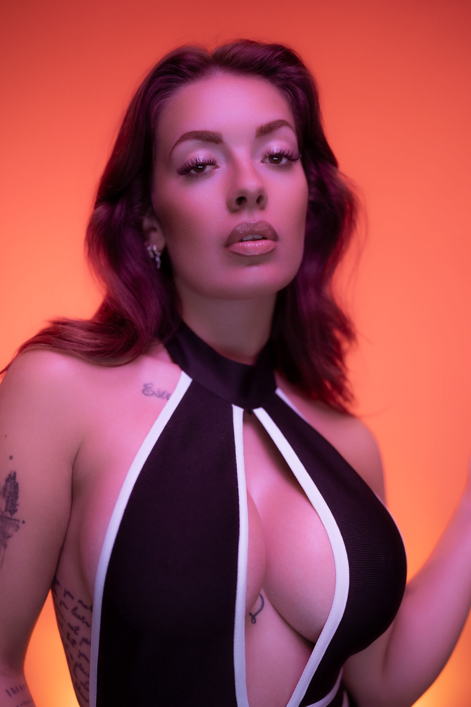 Side view of a model with purple-pink LED light, wearing a cut-out dress during a creative workshop with Nanlite lighting in Copenhagen.