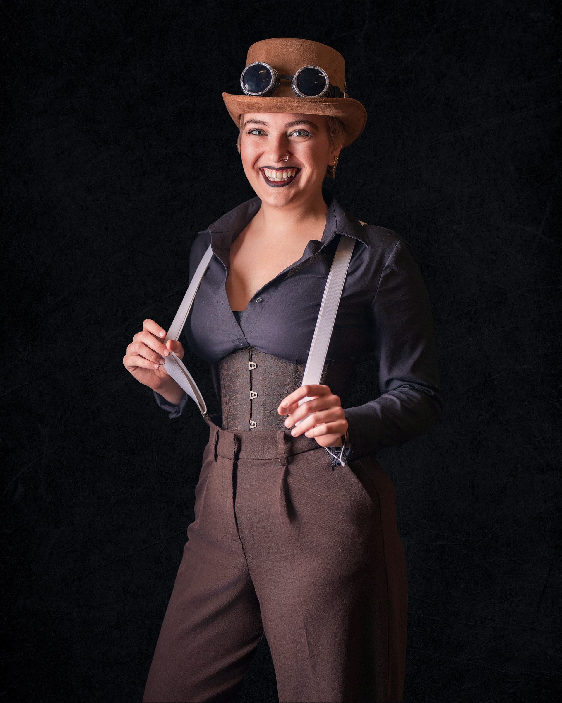Smiling steampunk cosplay photoshoot featuring Tirza in studio lighting with character styling
