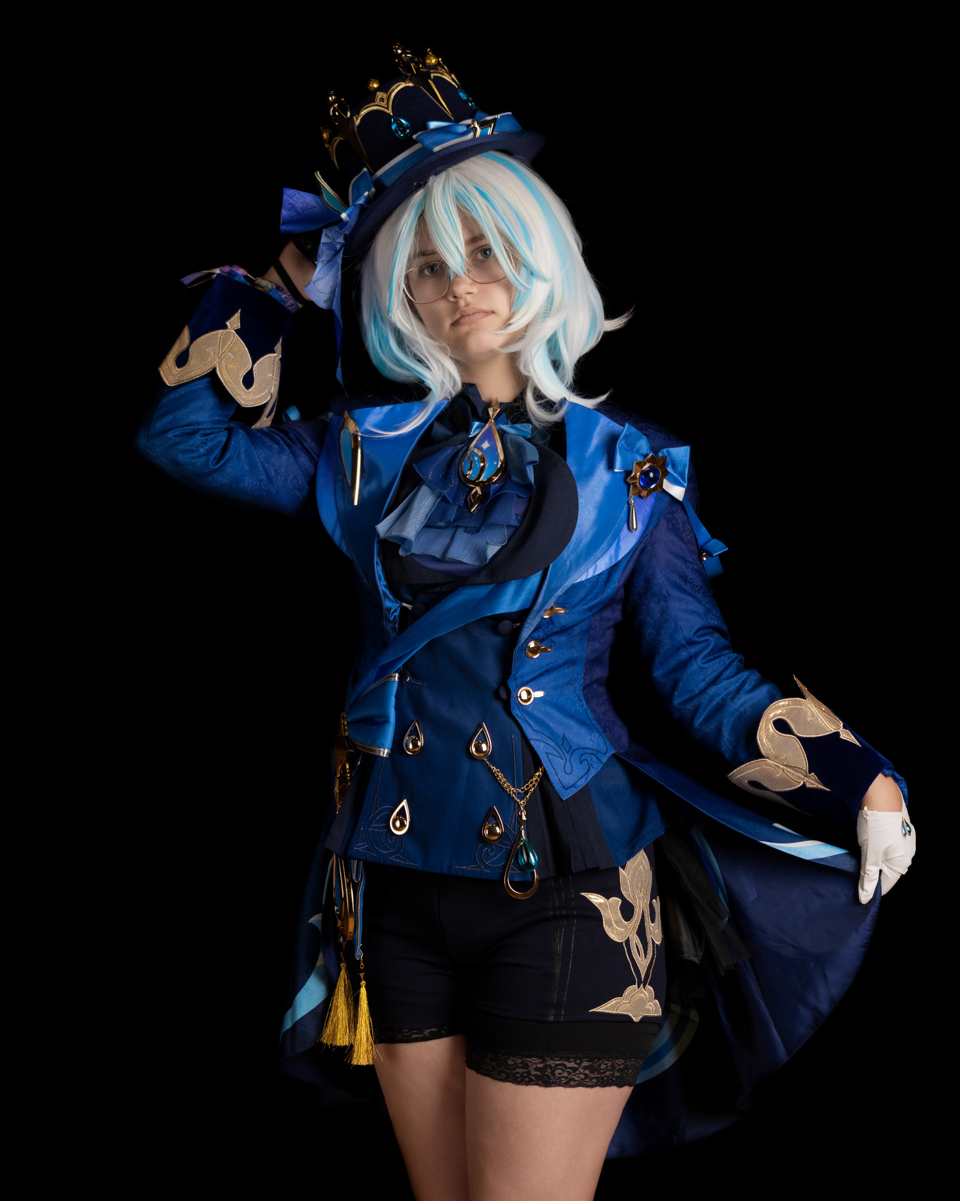 Close-up studio portrait of Furina de Fontaine cosplay with crown, white-blue wig and dramatic fantasy lighting.