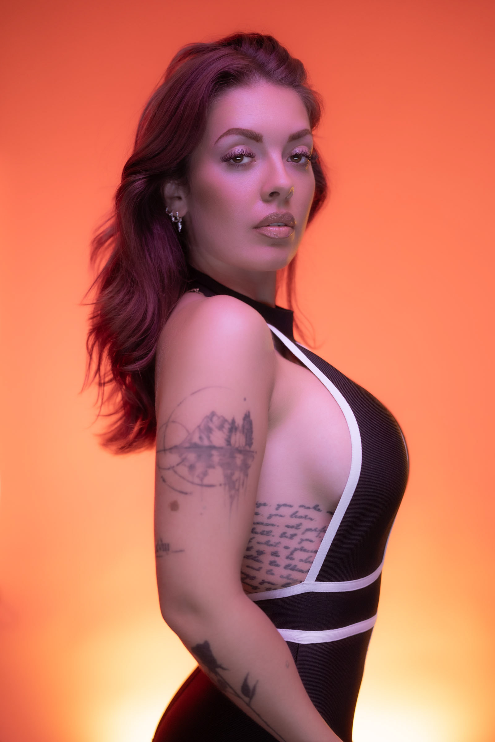 Close-up fashion image using colorful LED lights and Sony cameras, highlighting the model’s expression and tattooed side.