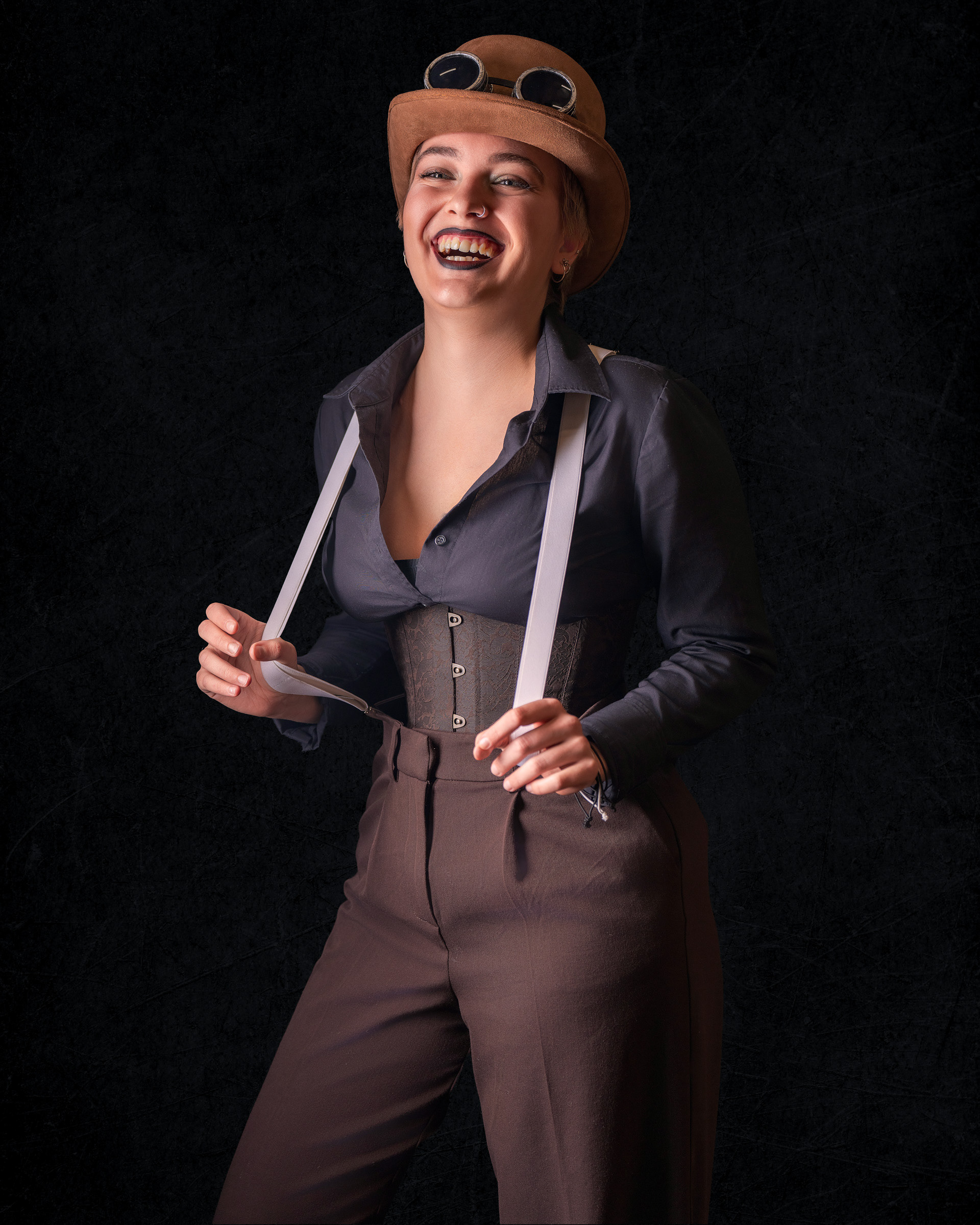 Playful studio portrait of Tirza wearing steampunk costume with cinematic lighting