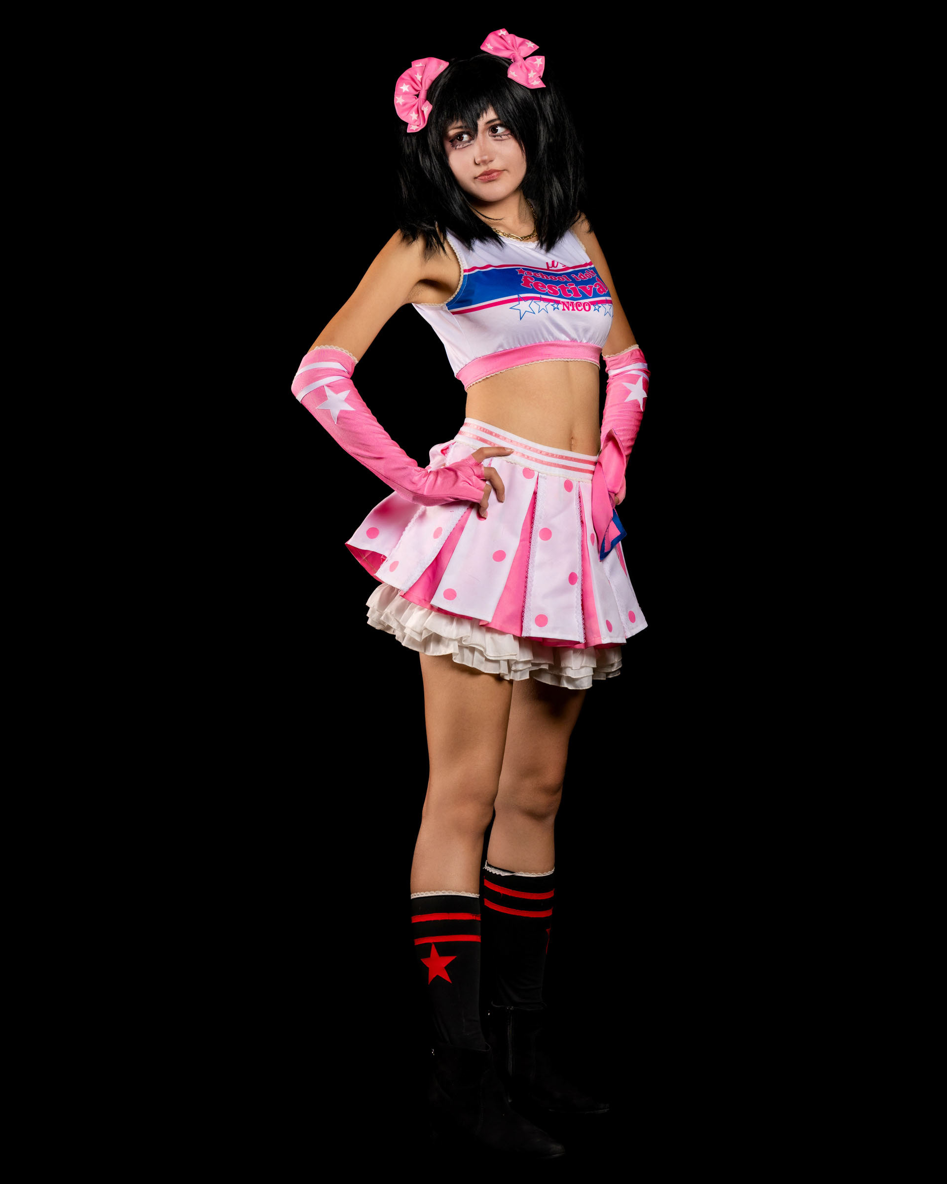 Studio portrait of may_c0z as Nico Yazawa posing with a peace sign in a pink and white idol costume from Love Live School Idol Festival.