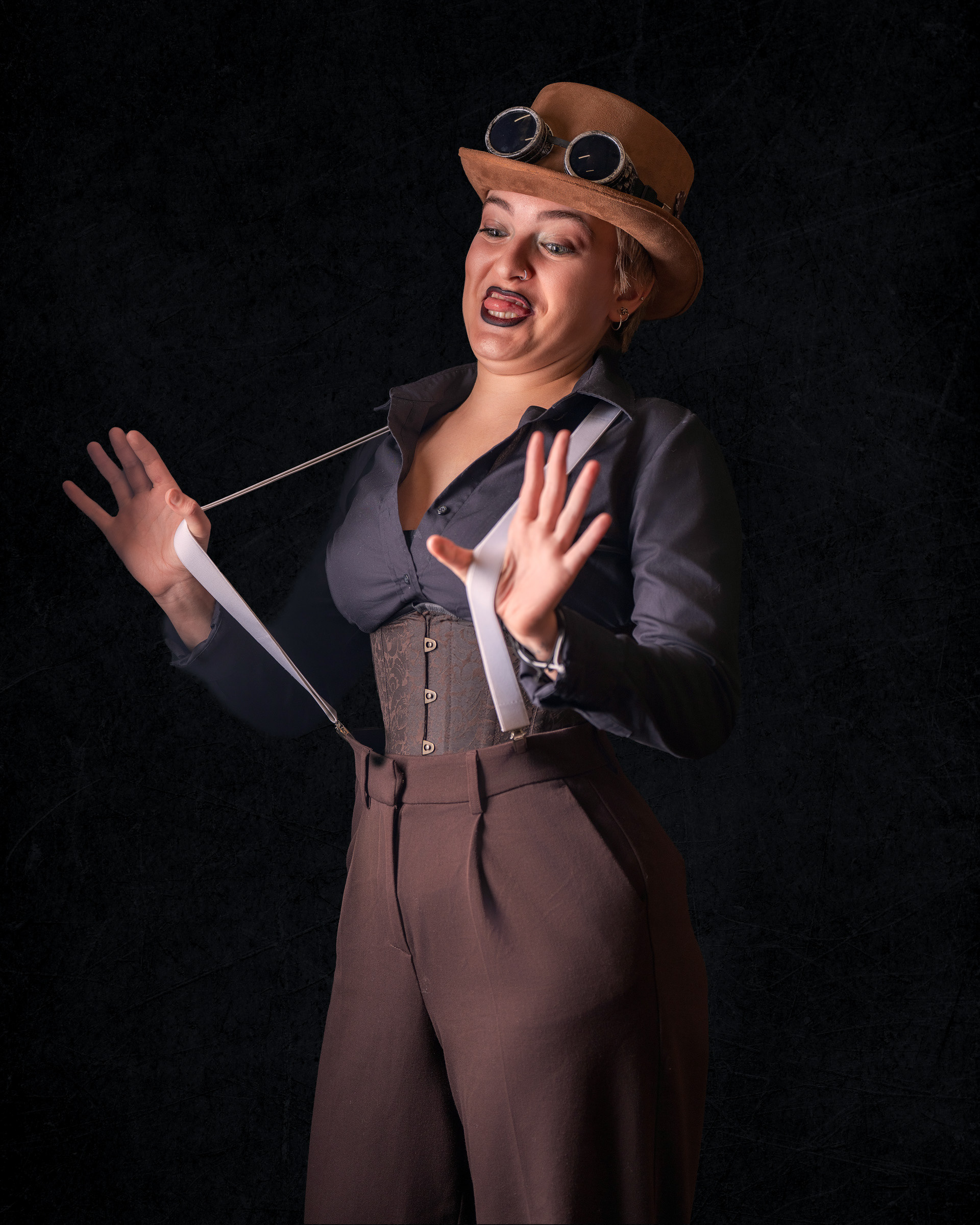 Studio portrait of model Tirza in steampunk cosplay outfit with expressive pose and dark background