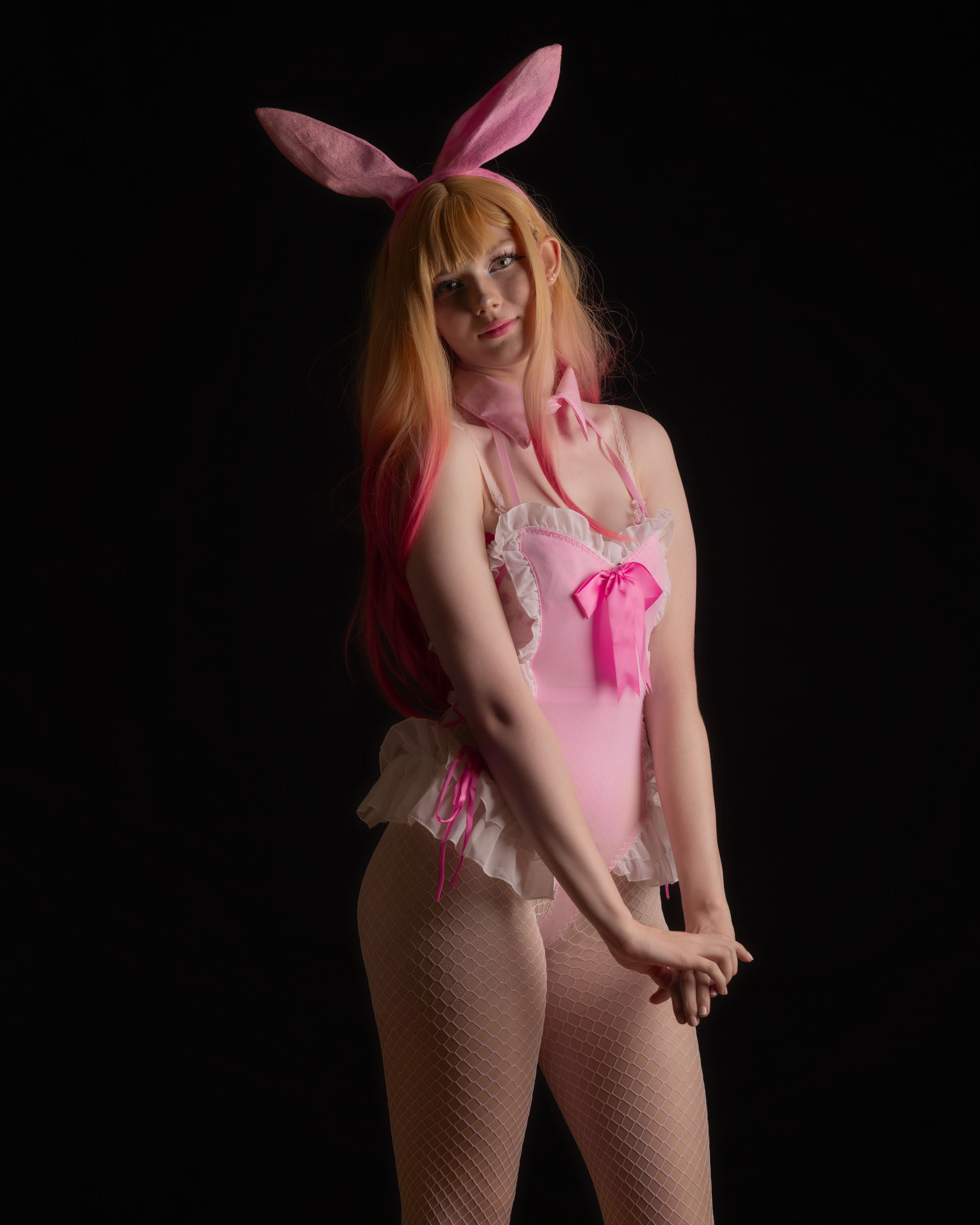 Rear-angle shot of Ninu in bunny cosplay, soft sensual pose with pastel colors and fluffy tail.