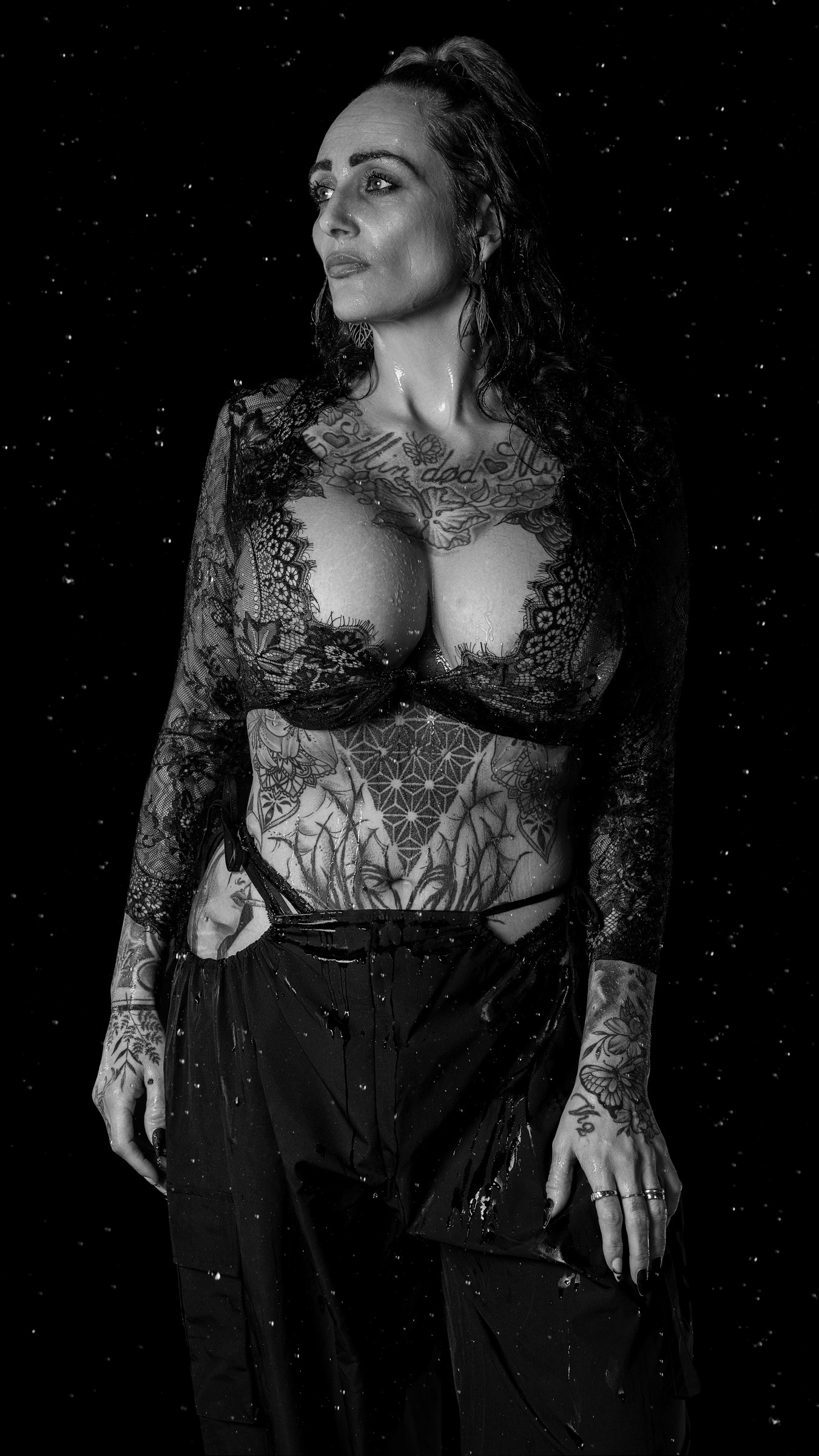 Black and white studio portrait of model Terese in lace lingerie with rain effect and dramatic lighting