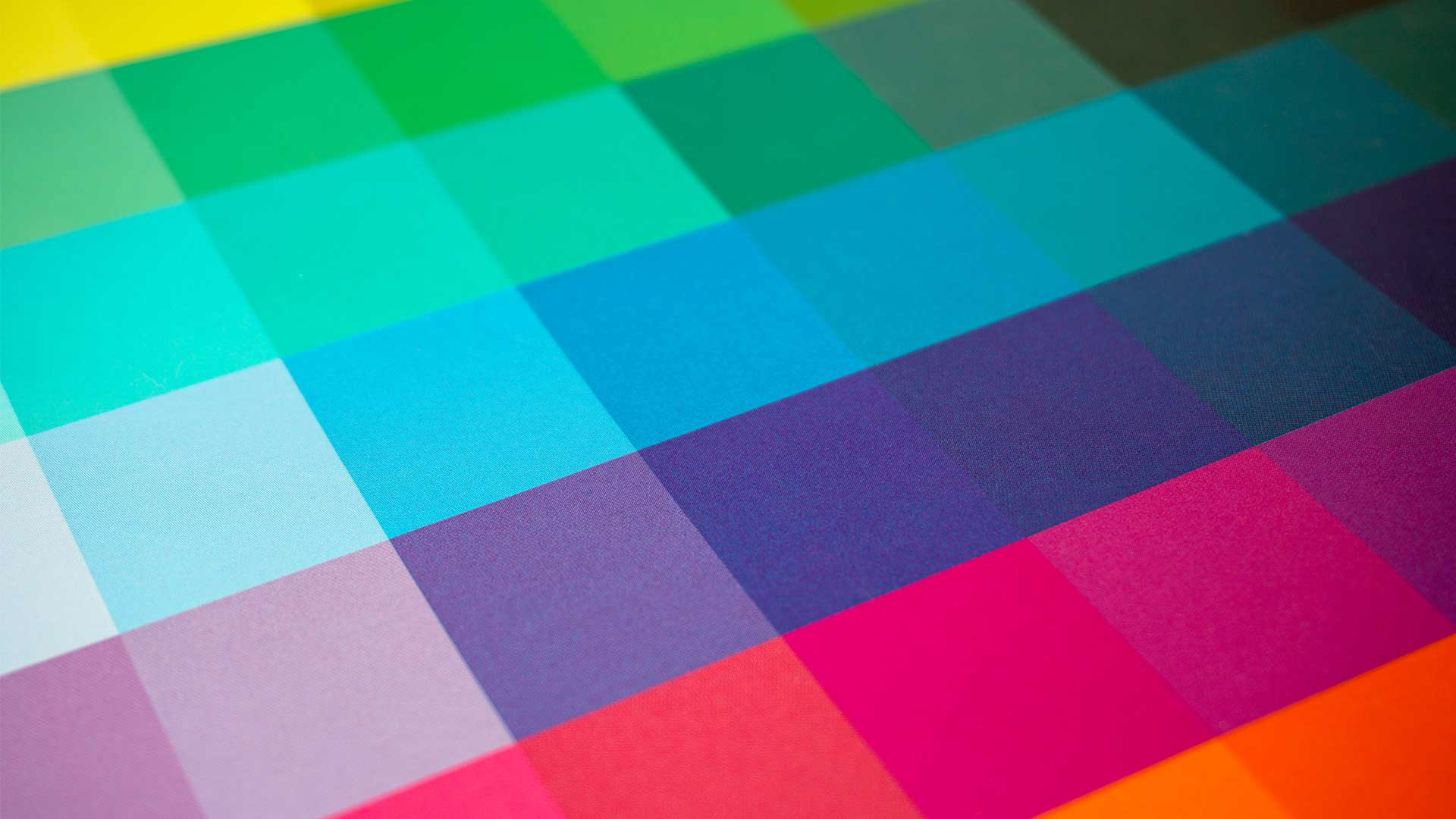Close-up of color swatches or paint chips arranged in a fan shape, creating a vibrant, colorful background for a color theory banner.
