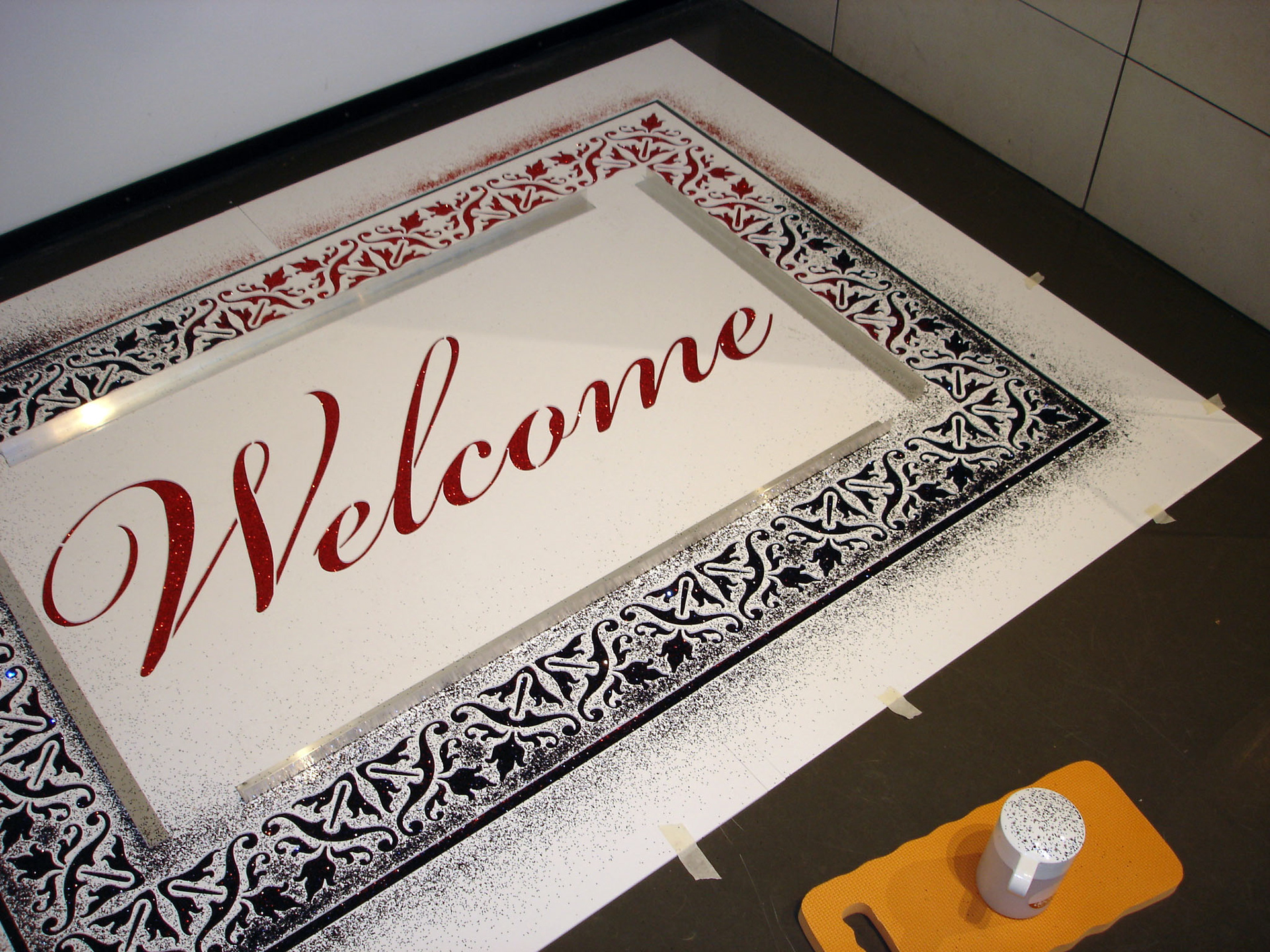 Glitter carpet installation using stencil