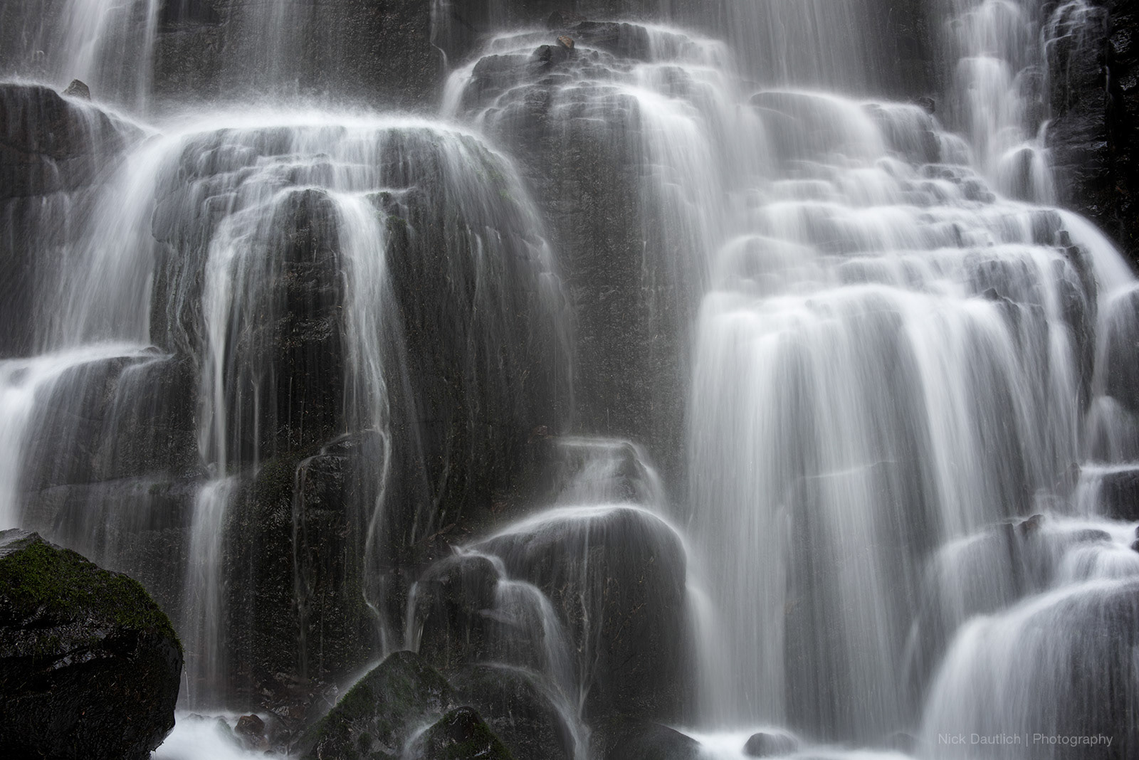 A waterfall detail with water cascading down tiers of rocks
