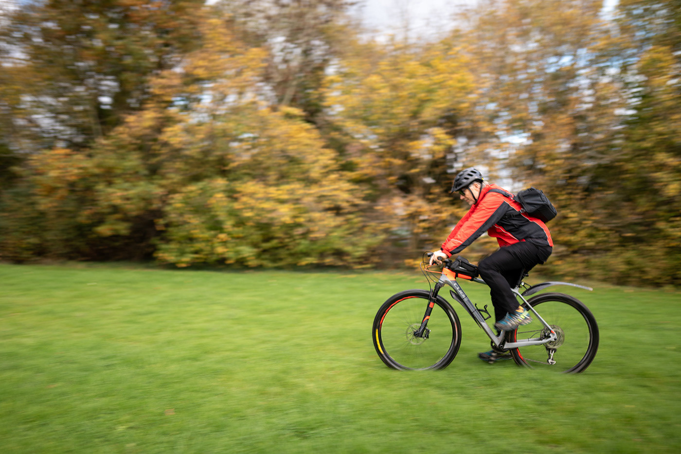 MTB cycling across a trail with the WotanCraft Easy Rider V2 camera sling