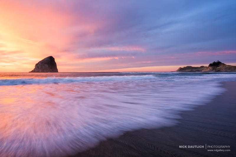 Fiery pink sunset in Pacific City with waves crashing on the beach
