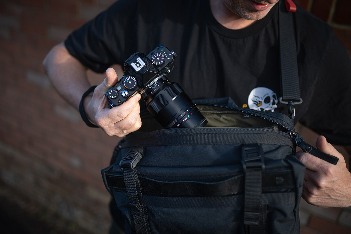 Grabbing NIkon camera with Voigtlander lens from the camera bag