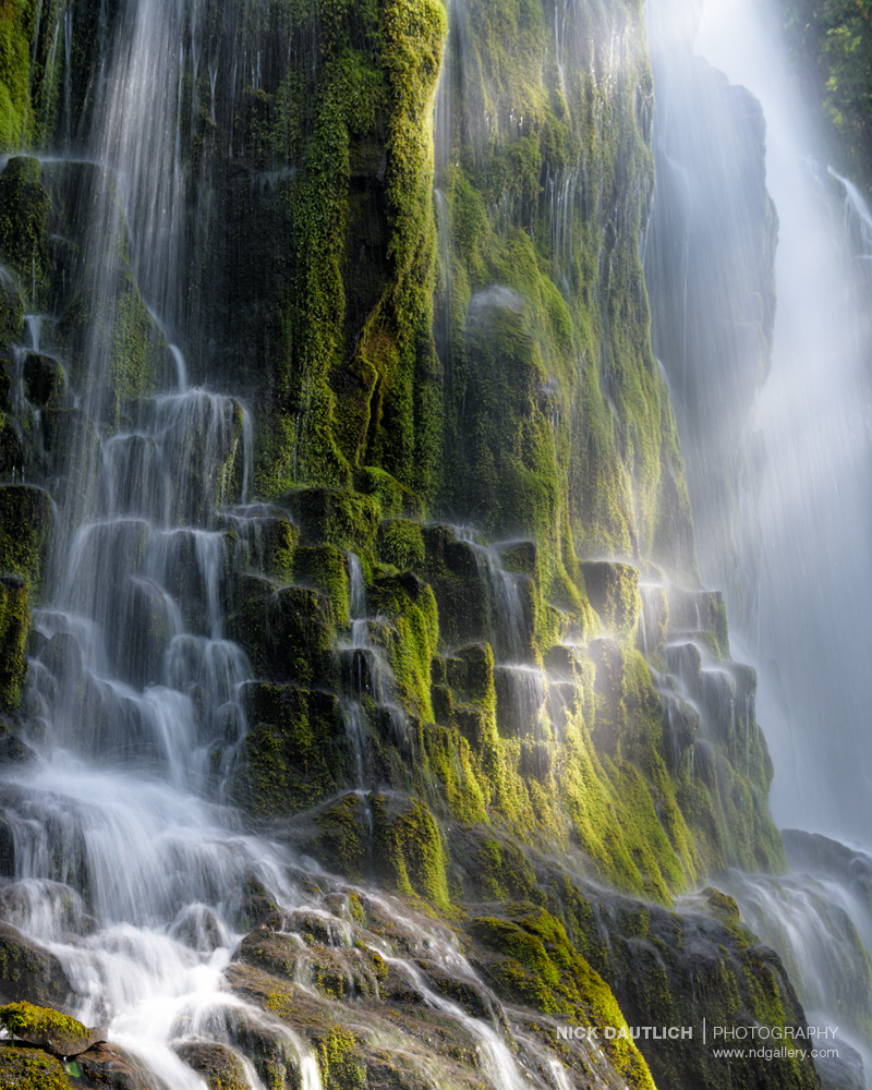 Light filters through misty waterfall closeup photo