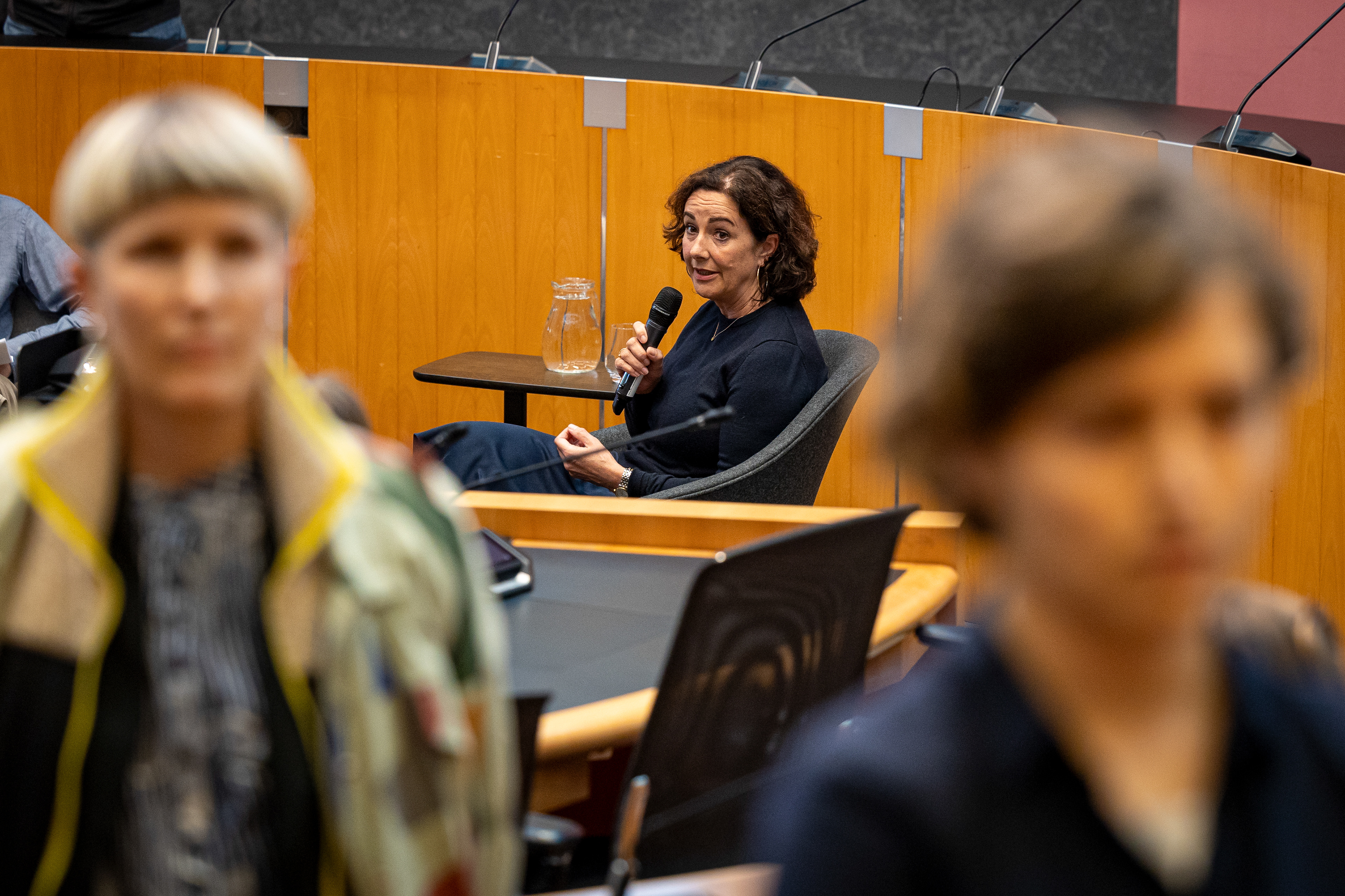 Burgemeester Femke Halsema te gast bij Room for Discussion van de UvA, enkele aanwezige studenten keren haar de rug toe.