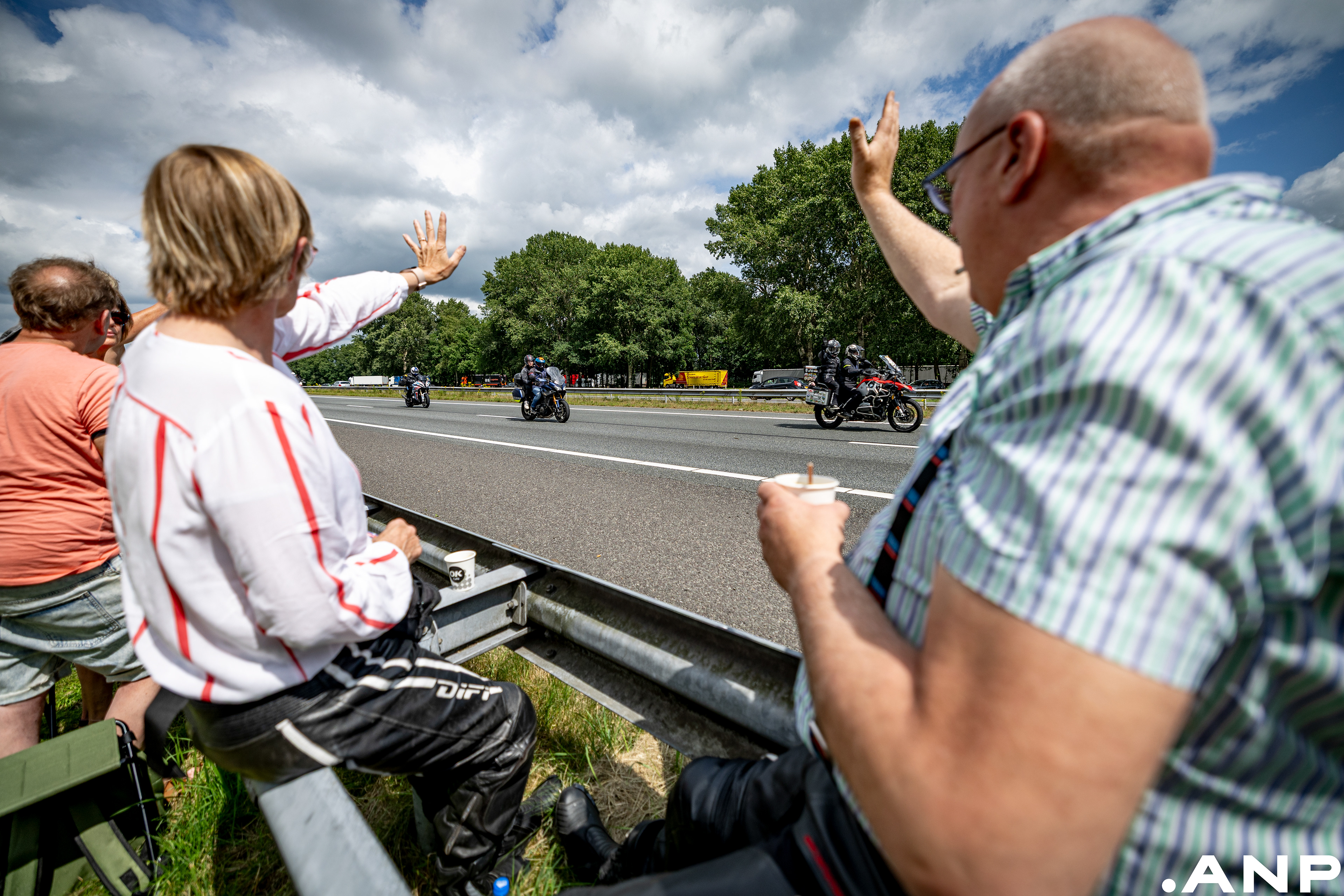 Racefans zwaaien motoren uit bij tankstation De Mussels langs de A28 bij Bijlen. Na de 100e editie van de TT van Assen. I.o.v. ANP
