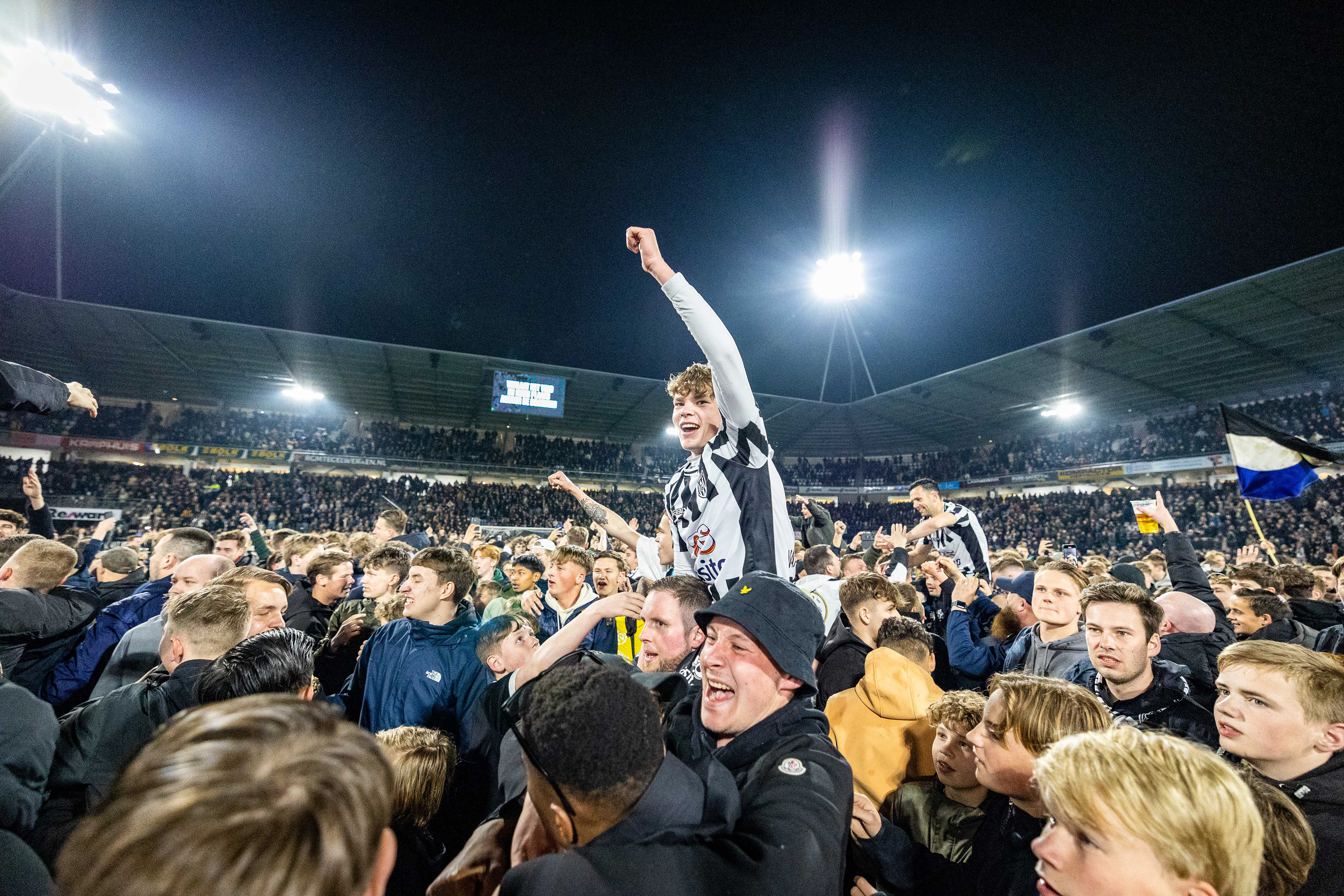 Diego van Oorschot viert promotie van Heracles op schouders supporters
