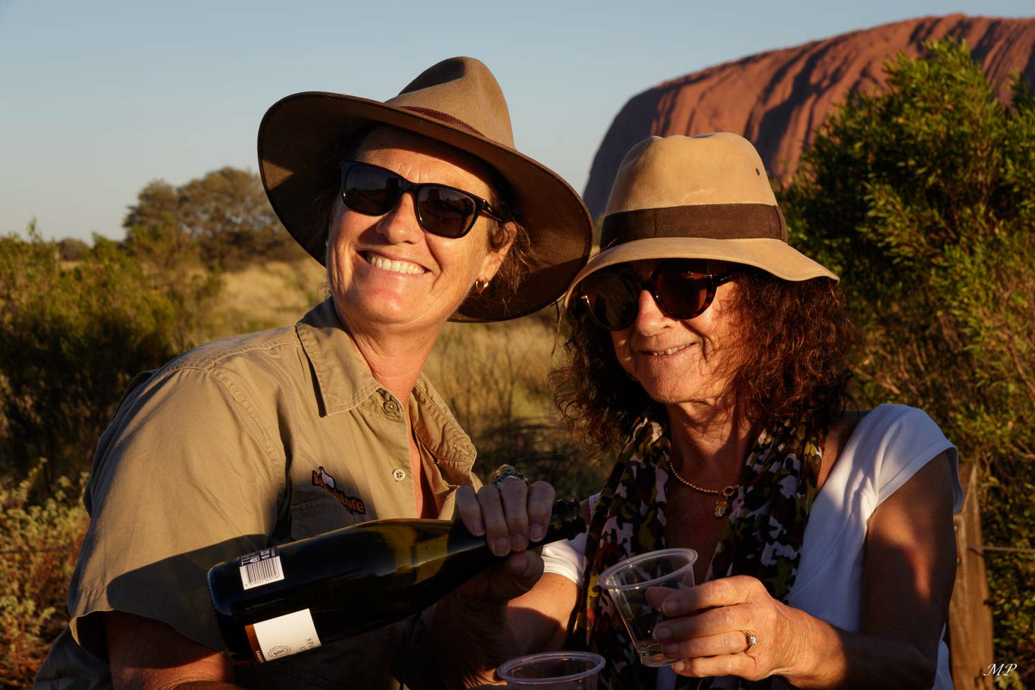 Pour célébrer le rituel crépusculaire, boire  un verre de pétillant devant le rocher au coucher de soleil est une tradition touristique.