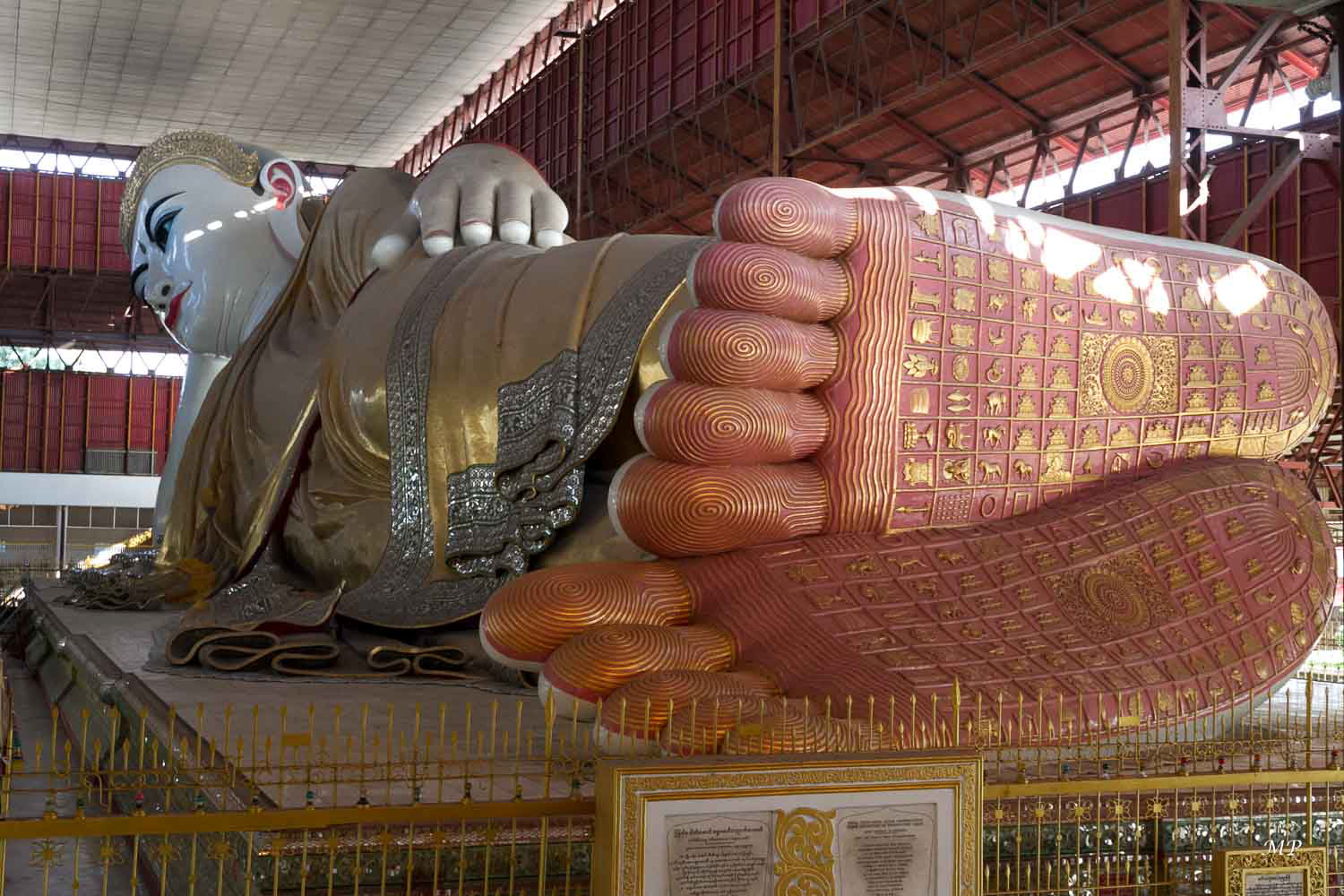 Yangon - Paya Chaukhtatgyi: Il y a un demi-siècle se dressait ici un immense bouddha. Mais un jour, il s'effondra, et fut remplacé en 1980 par ce colossal bouddha couché à l'allure sereine. Il est coiffé d'une couronne incrustée de diamants et d'autres pierres précieuses. Recouvert à la feuille d’or, il est doté d’un toit pour le protéger des intempéries. Quand les pieds d'un bouddha sont décalés, cela signifie qu'il se repose tout simplement.