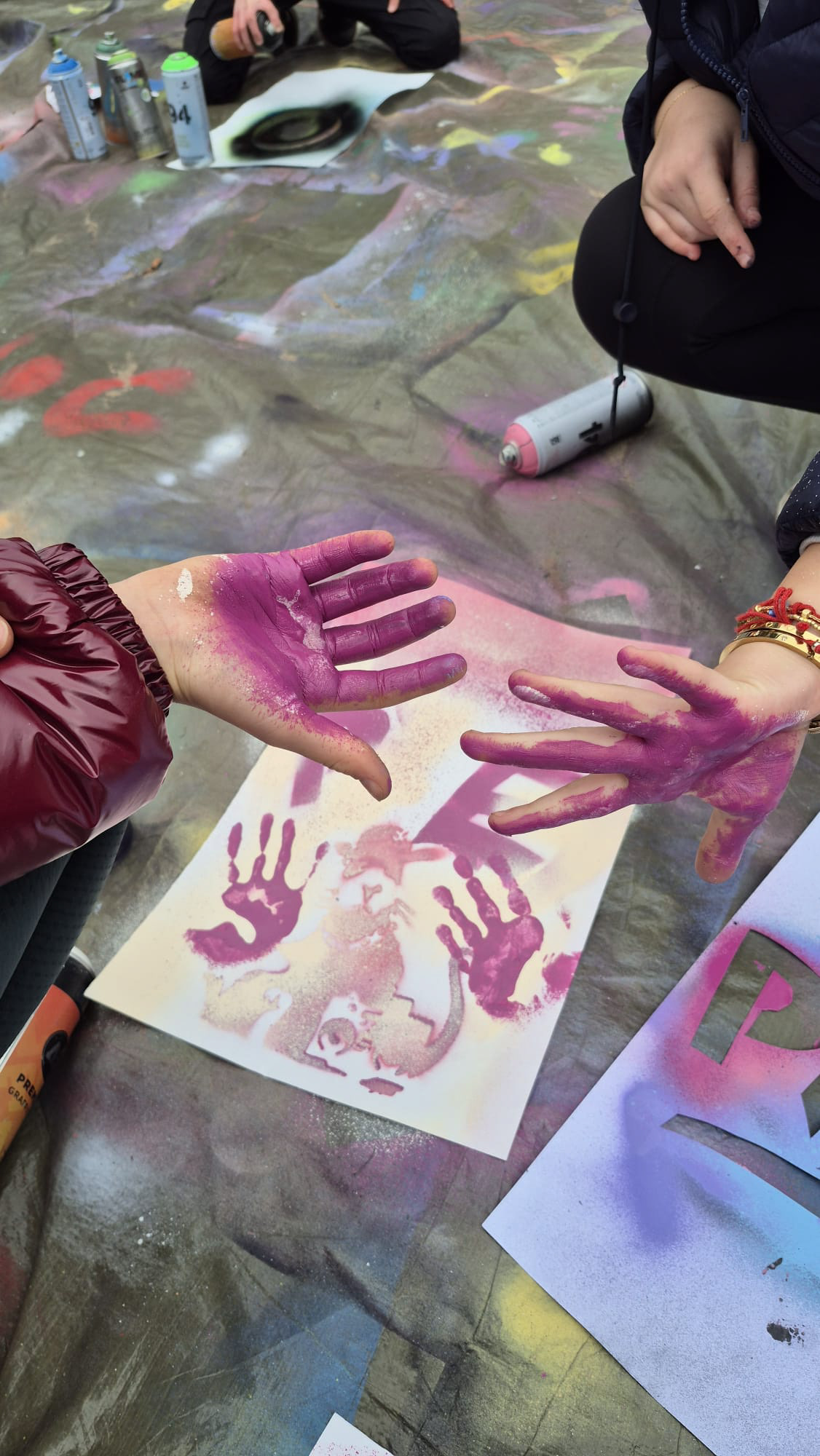 Kind laat trots zelfgemaakt stencil-kunstwerk zien