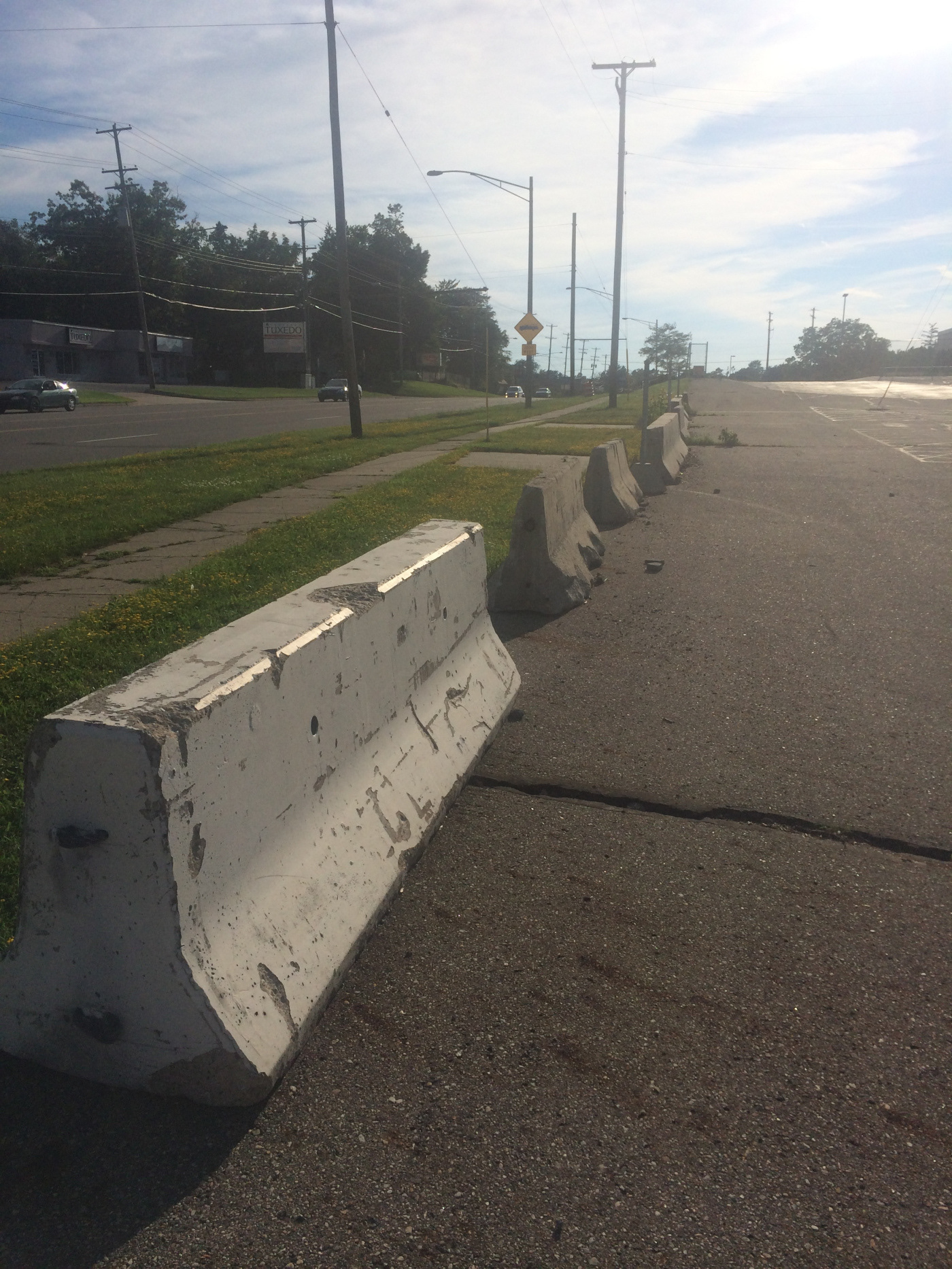 Road barriers line the parking lot of the former Lansing Metal Center.