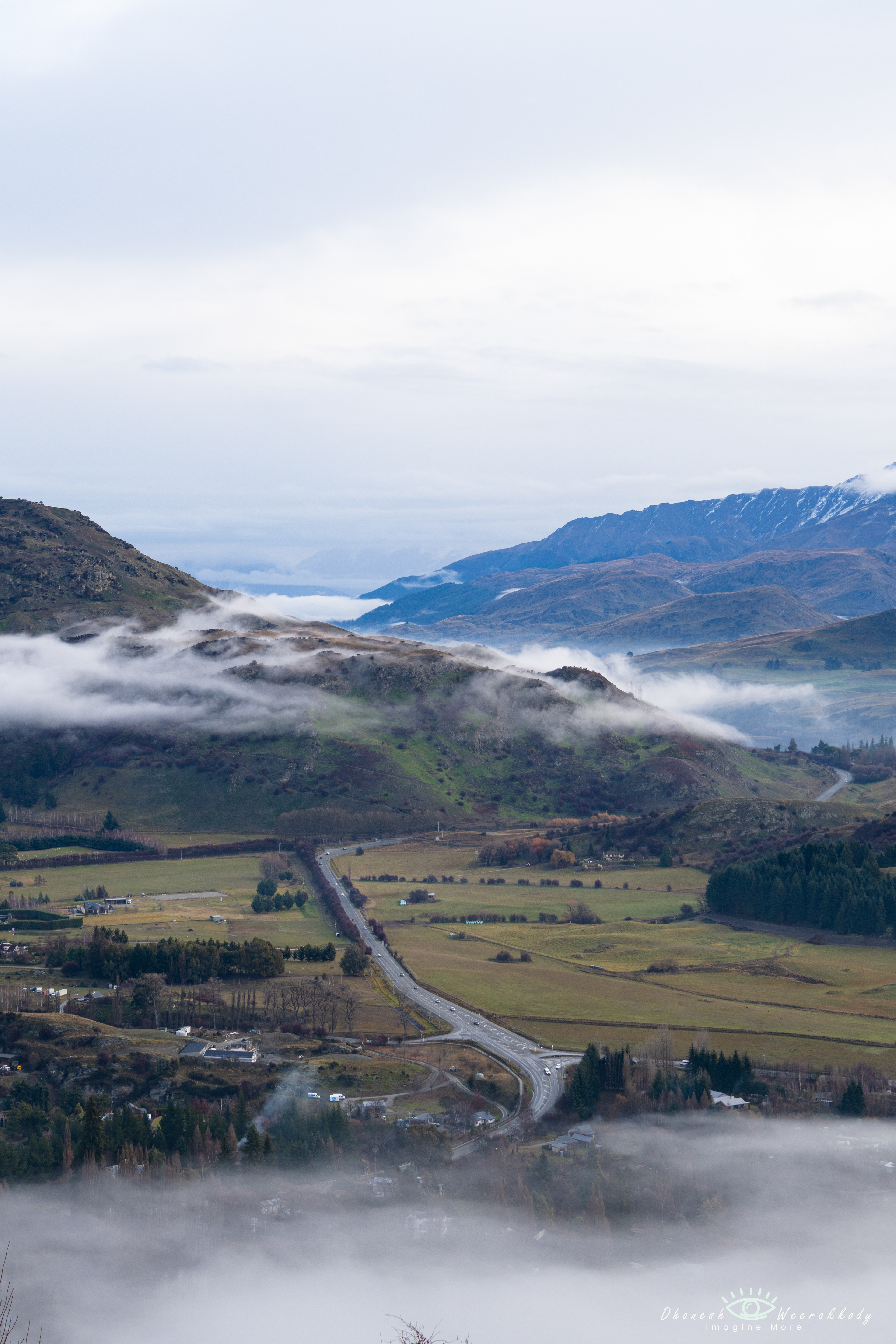 Scenic Landscape –Queenstown to Wanaka (June 2023)  Captured at the start of winter, this stunning view from Queenstown to Wanaka showcases snow-dusted mountains, lush green valleys, and winding roads leading through the picturesque town below. A perfect blend of nature’s beauty and alpine charm in New Zealand’s South Island.