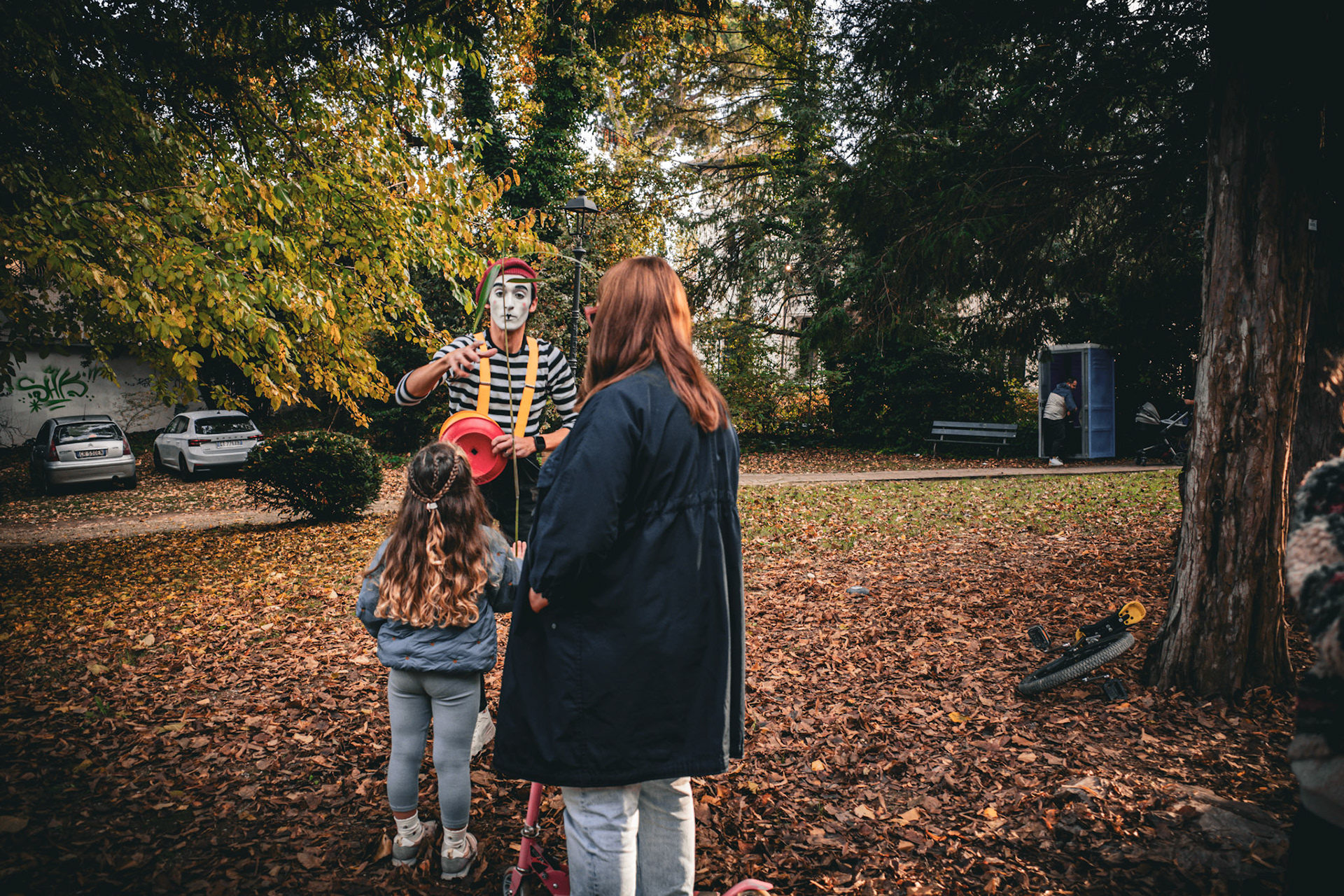 The enchantment suspended among leaves, a mime, a child, and Autumn listening
