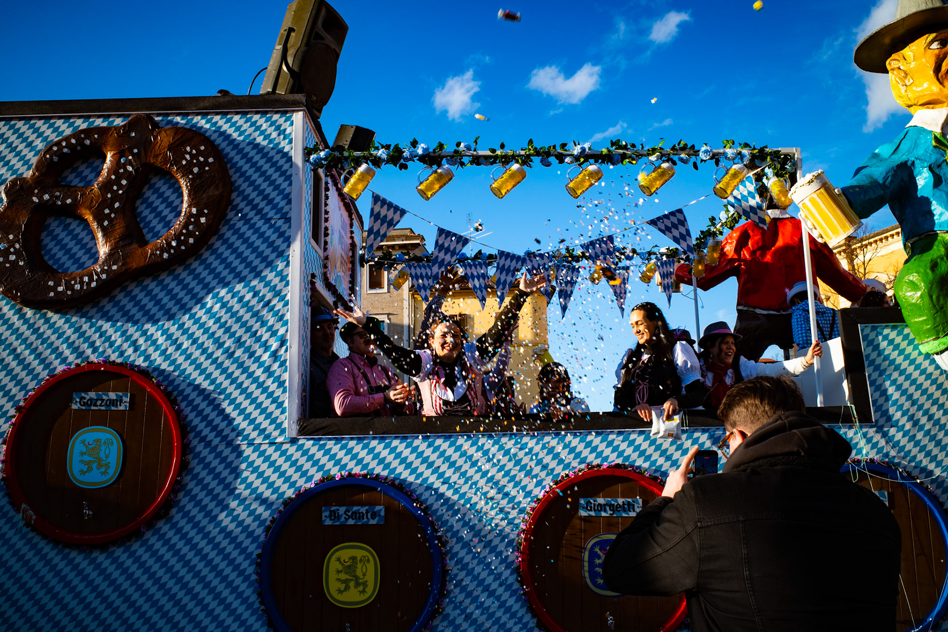Under a clean and noisy sky, celebration becomes a collective gesture. Raised hands, flying confetti, faces laughing without defenses. For a moment the city forgets the weight of days and allows itself lightness, letting color and sound take command.