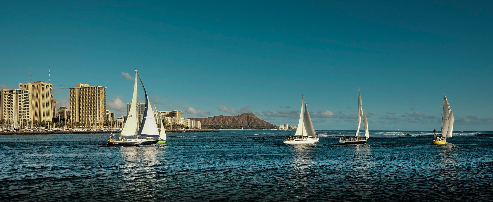Honolulu Yacht Club sailboats headed out to their weekly Friday night race.