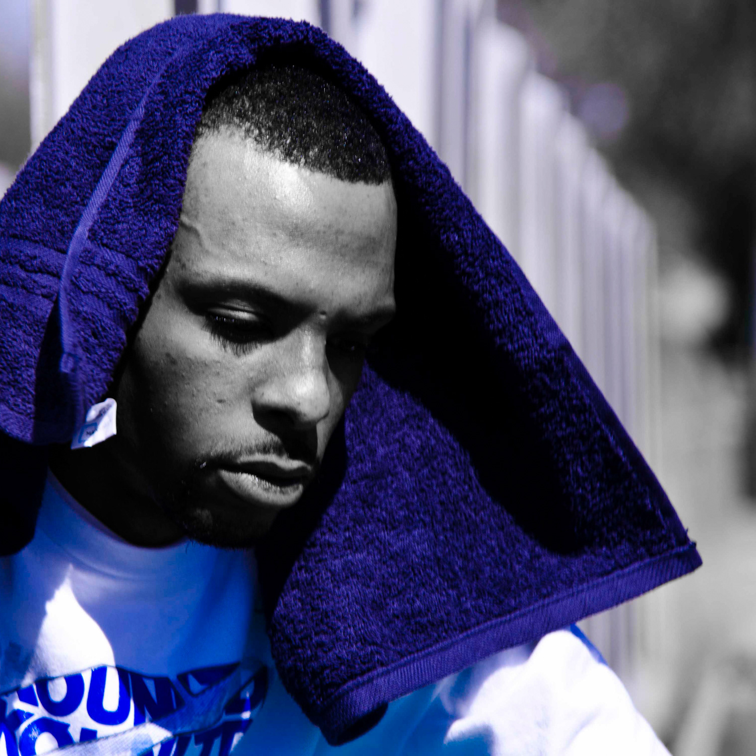 Zay The Beast is a monochromatic photography wearing a blue towel on his head. This image is featured on the official website of rapper/hip-hop artist Zay The Beast.