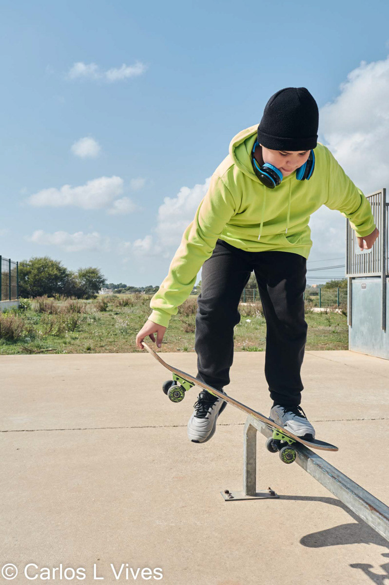 young, teenager, with a skateboard, jumping, on a track, skateboarding, wearing headphones
