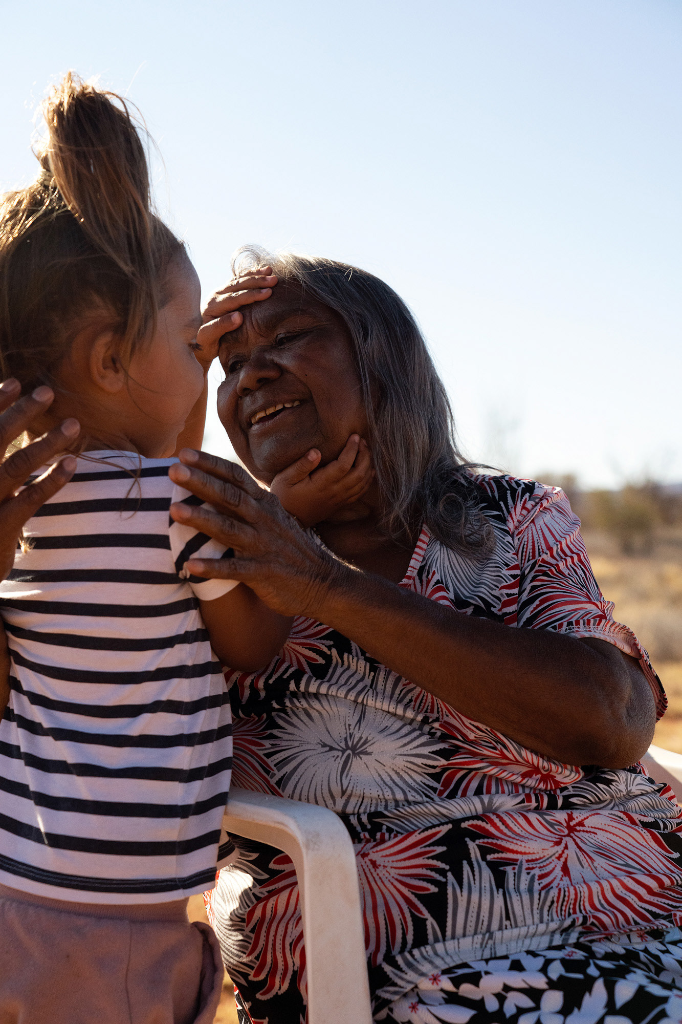 Kathleen Kemarre Wallace & granddaughter. Kathleen is an Eastern Arrernte woman, born in the Central Australian bush, and raised at Santa Teresa Mission from age 13. While at the mission, she was told to give her stories away, to forget them. But she refused and has kept them strong all her life.