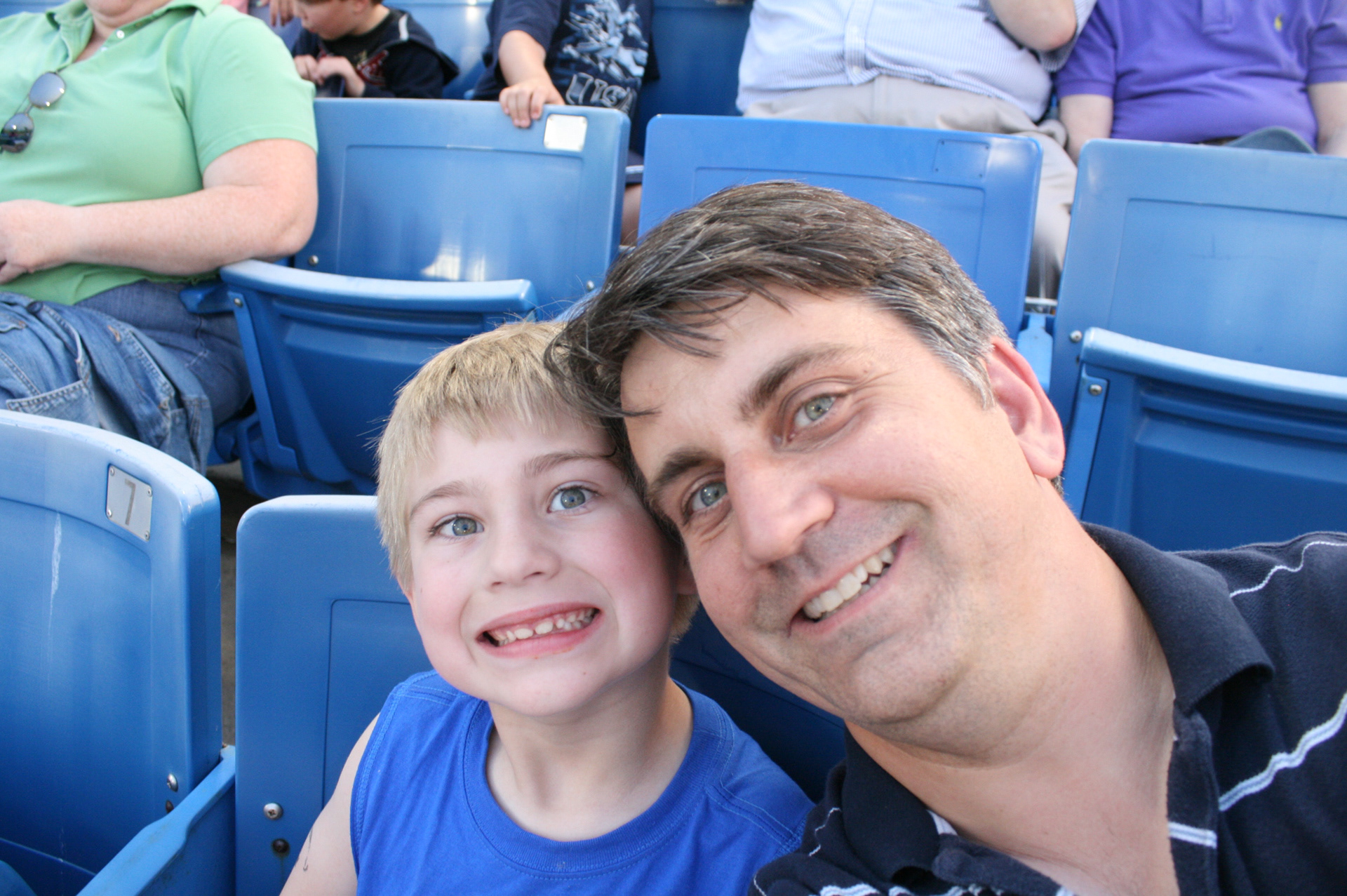 Ethan and dad squeeze in a moment during a baseball game.  As an infant, the steady pace of a televised game helped Ethan get to rest.